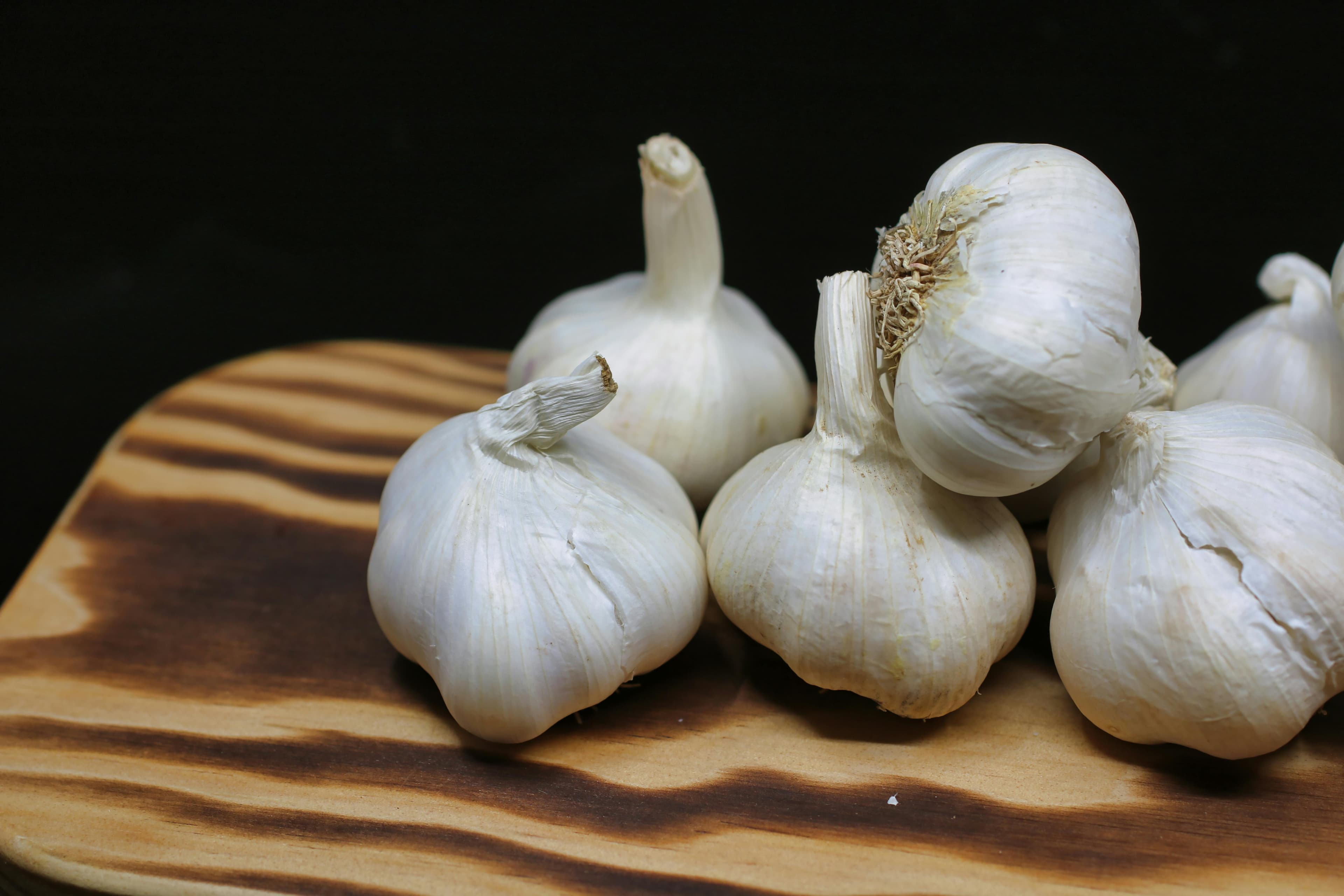 Fresh garlic cloves and a garlic press