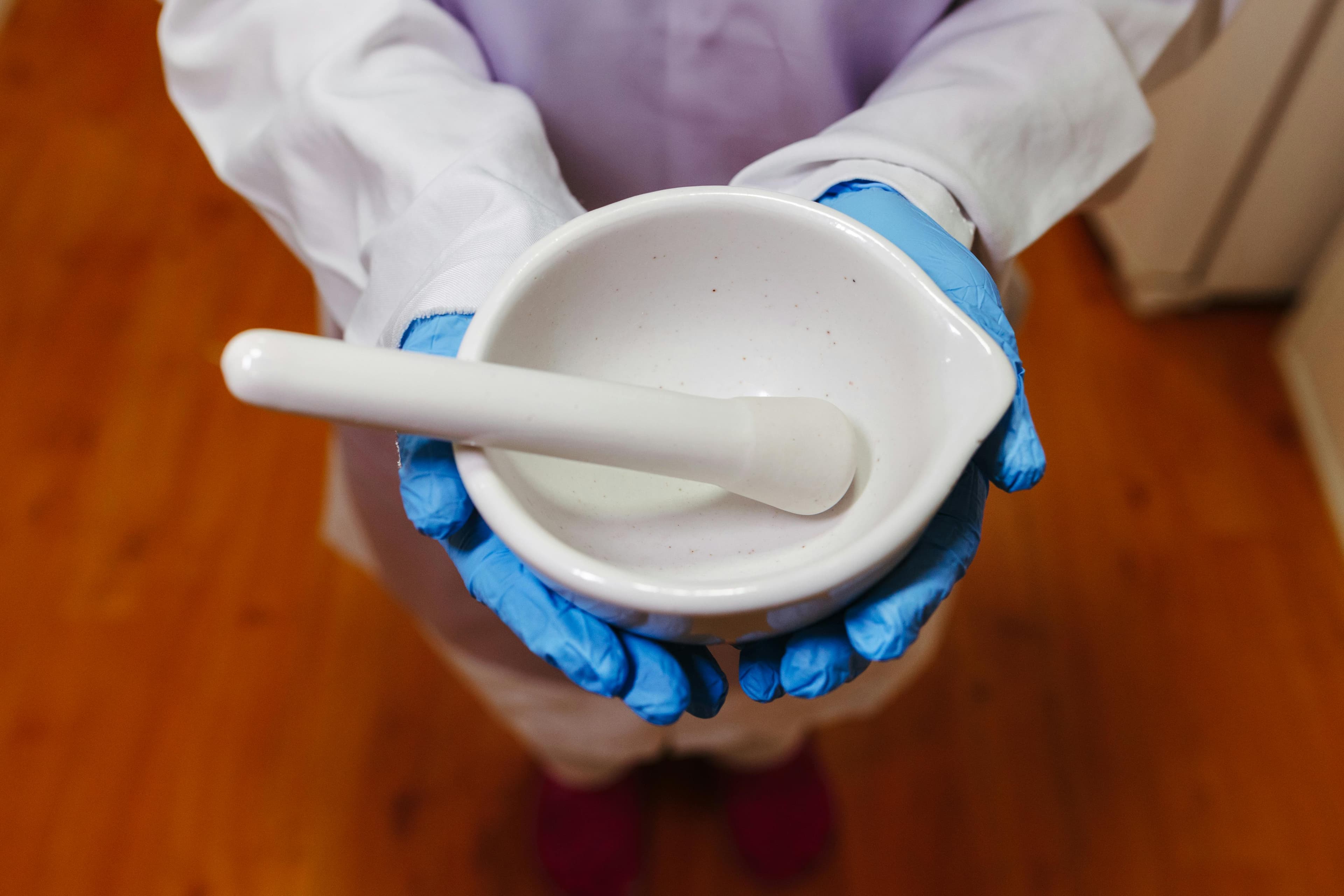 A pharmacist preparing compounded eye drops in a sterile laboratory setting