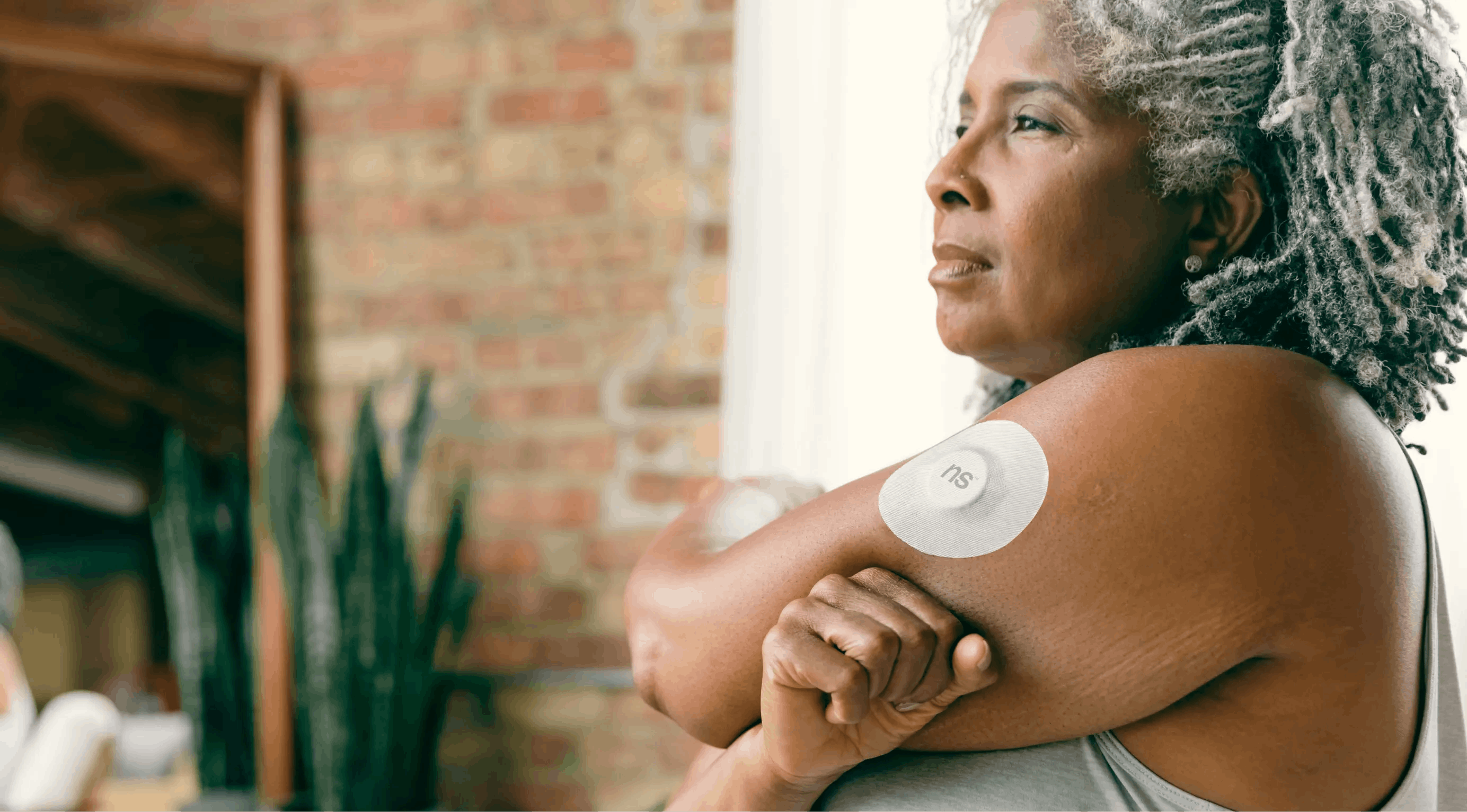A continuous glucose monitoring device attached to a person's arm