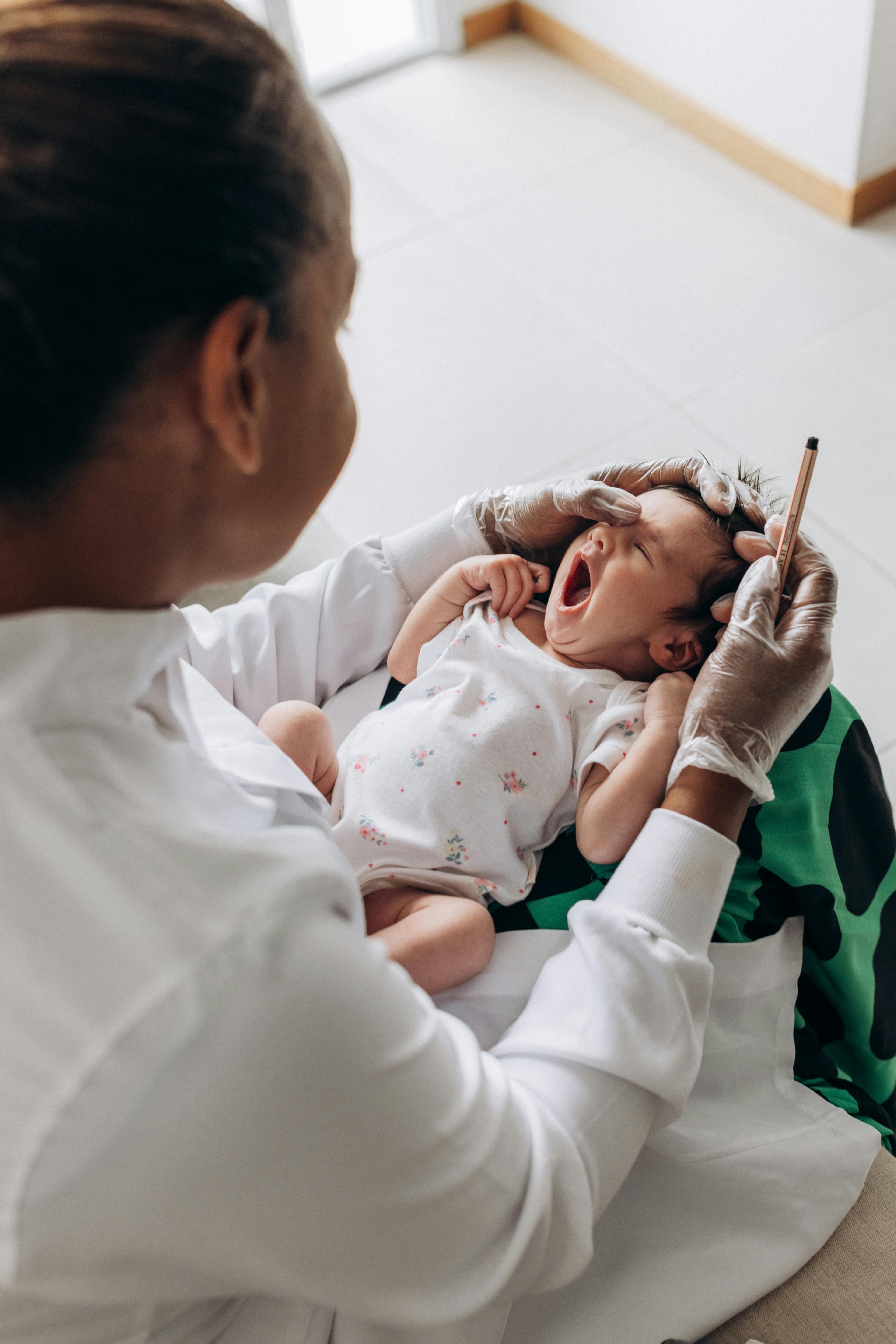 A pediatrician examining a baby