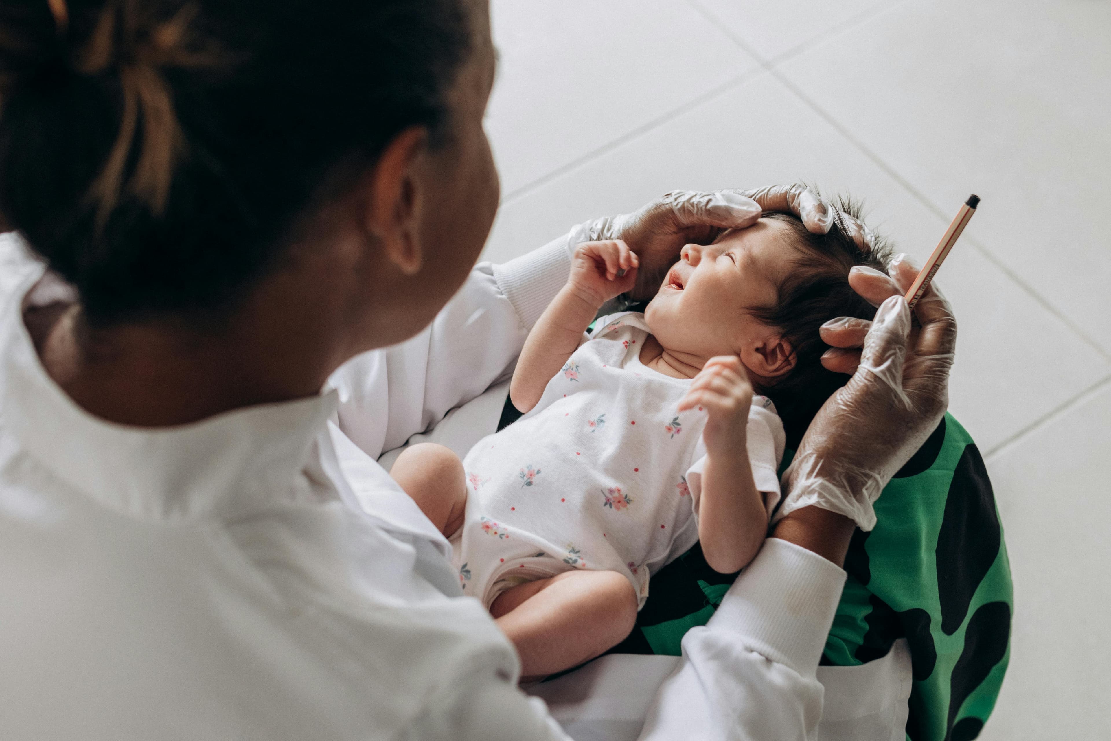A pediatrician examining a baby's eyes during a checkup