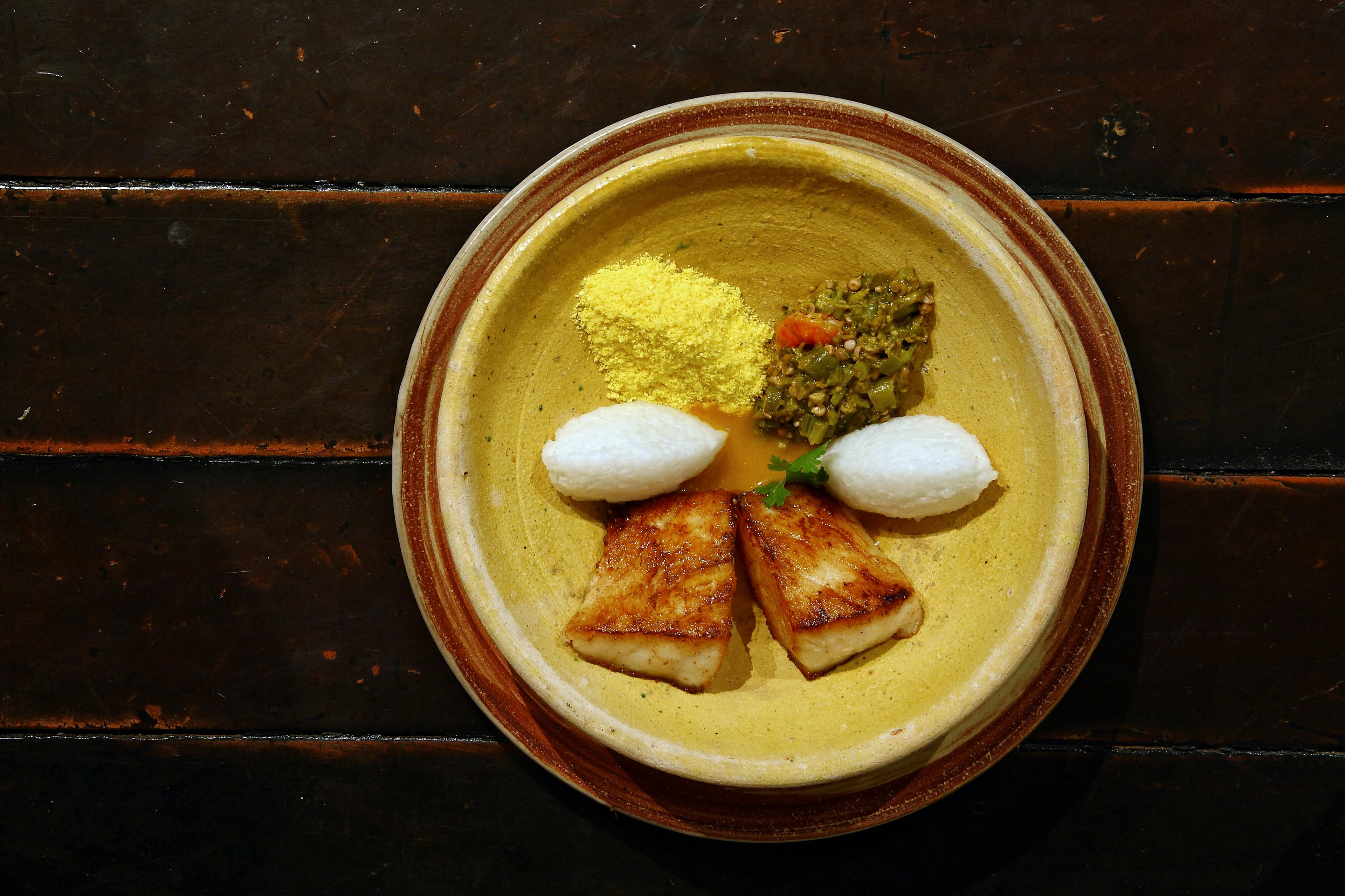 A plate with grilled red snapper, steamed vegetables, and a small portion of brown rice