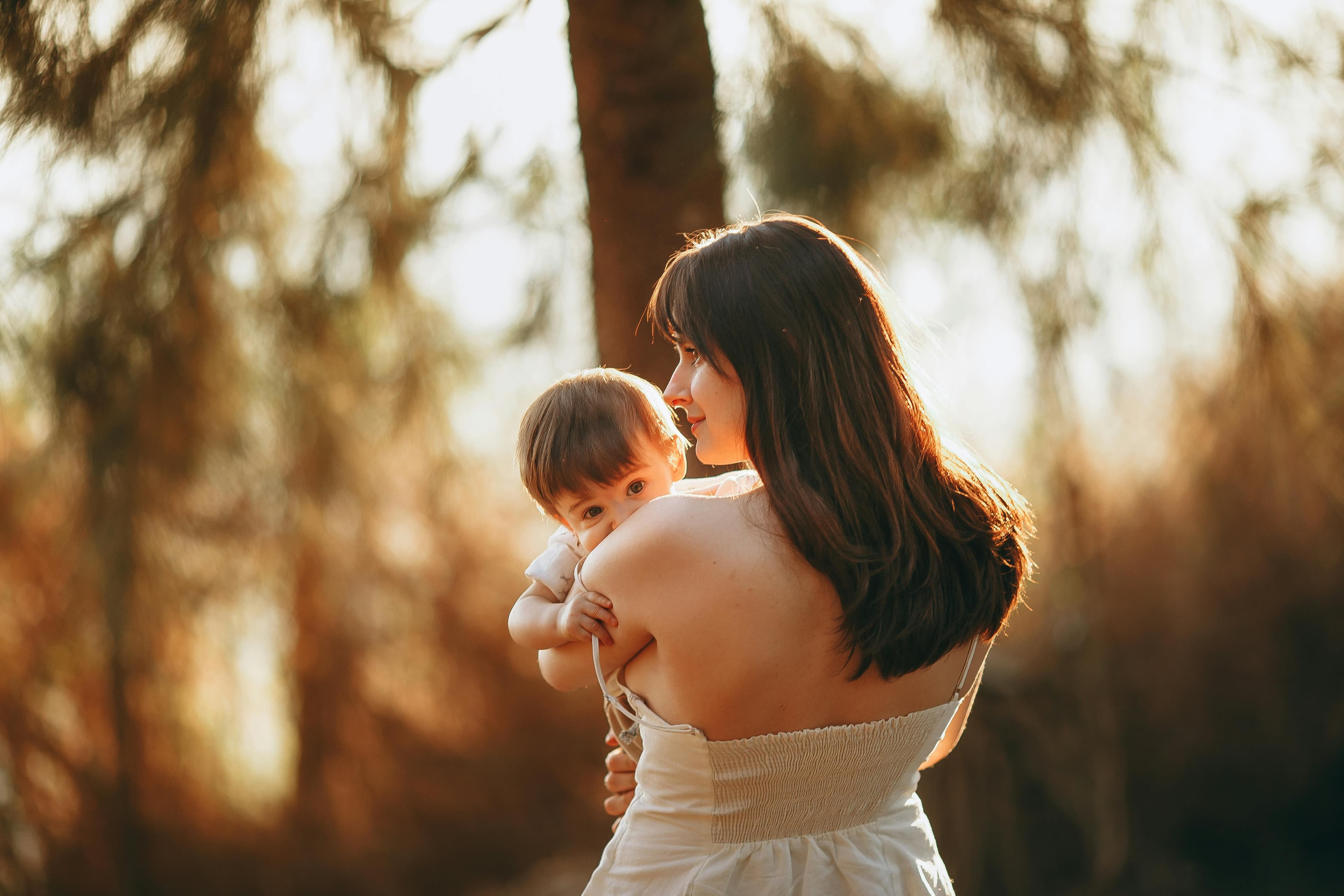 A parent burping a baby over their shoulder