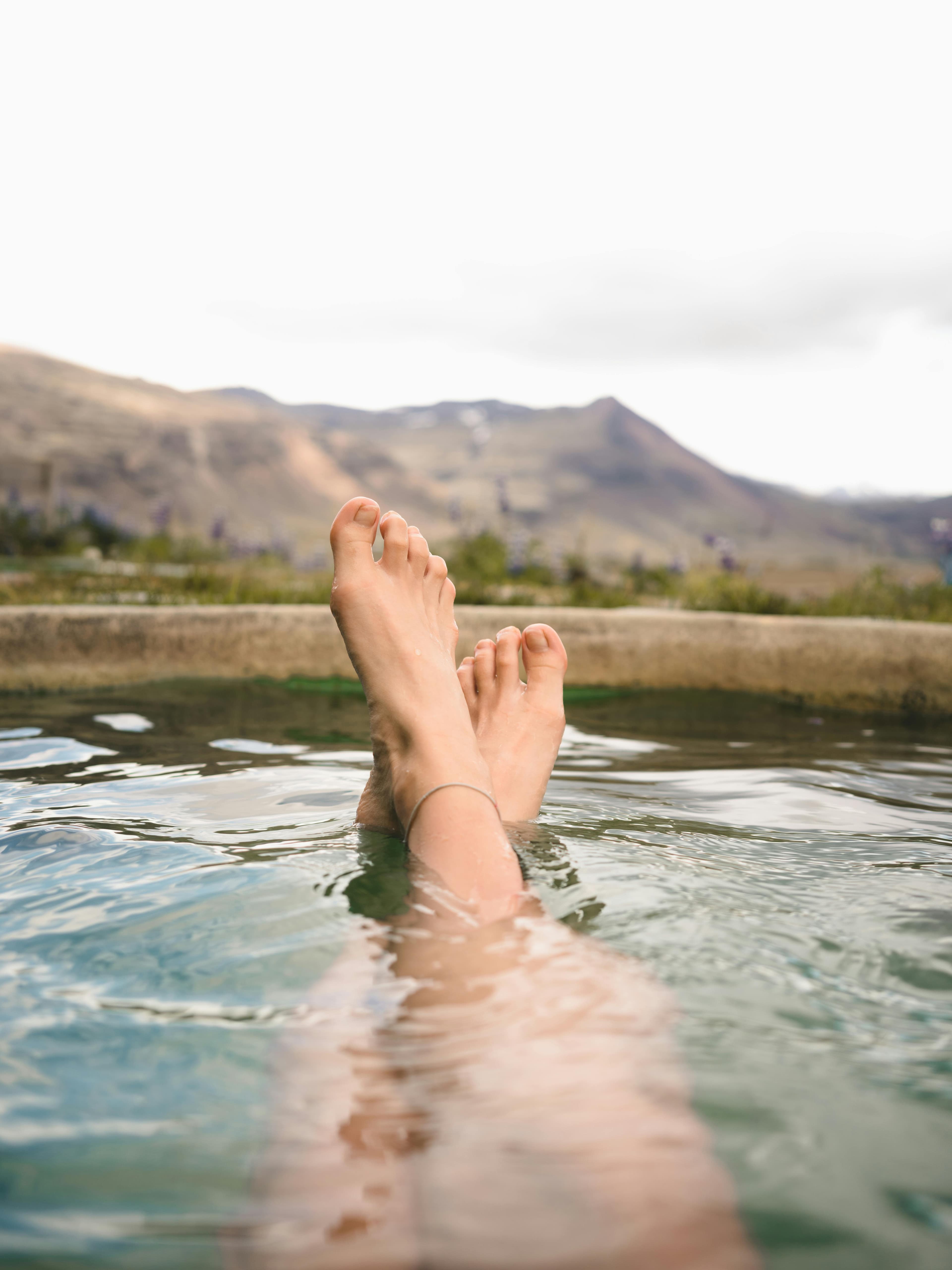 A person preparing an iodine foot soak in a basin
