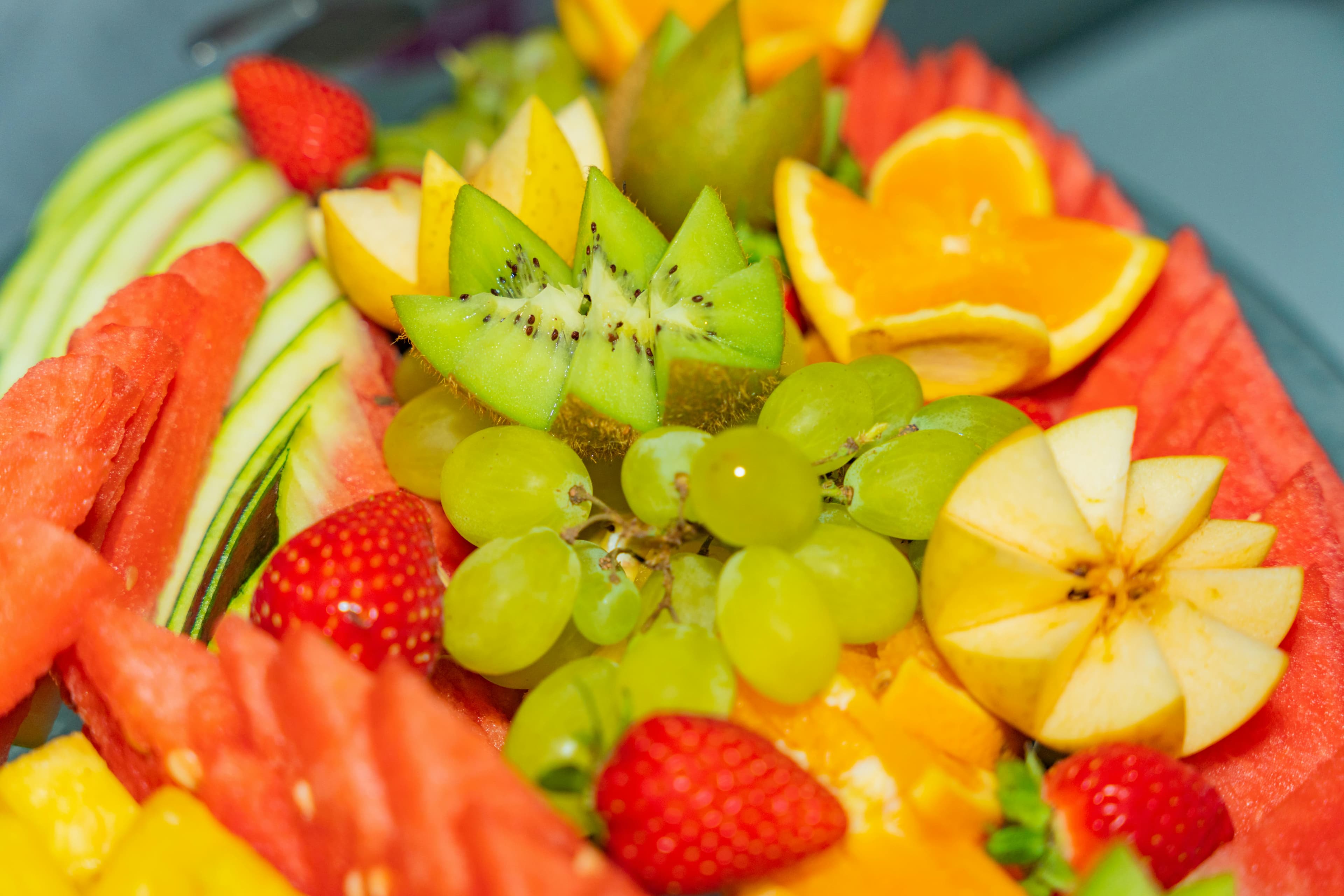 A healthy snack plate featuring apple slices, berries, and grapes