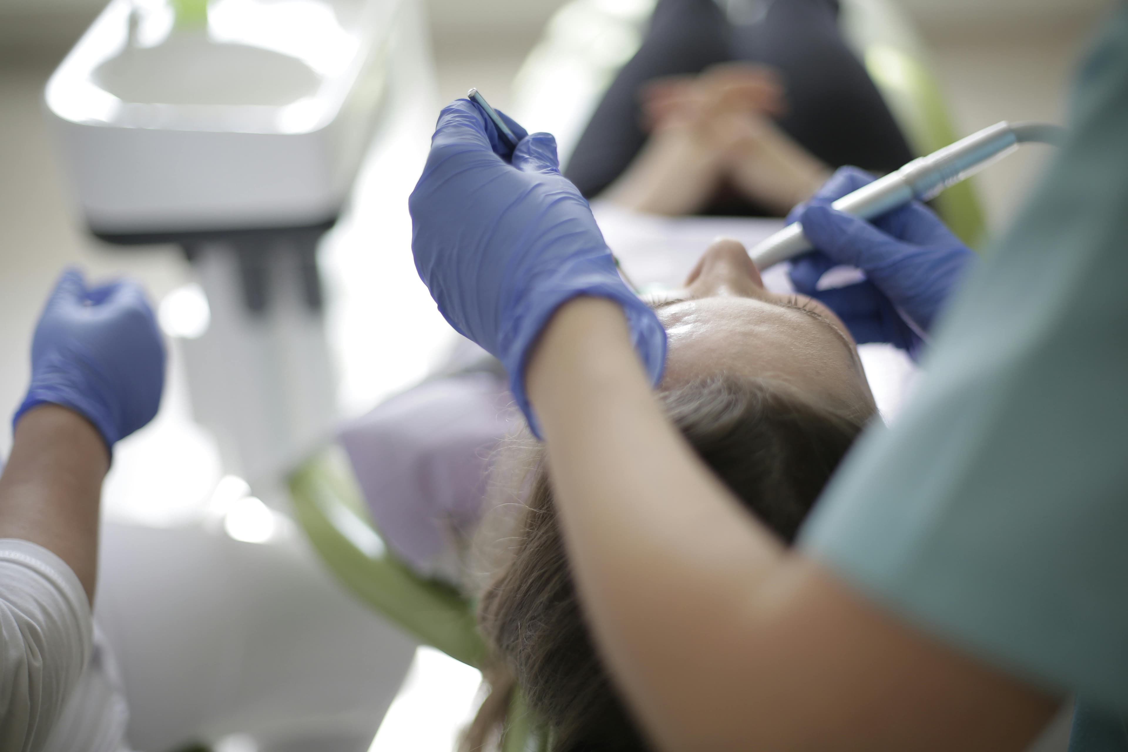 Doctor examining a patient's oral cavity for bumps or lesions