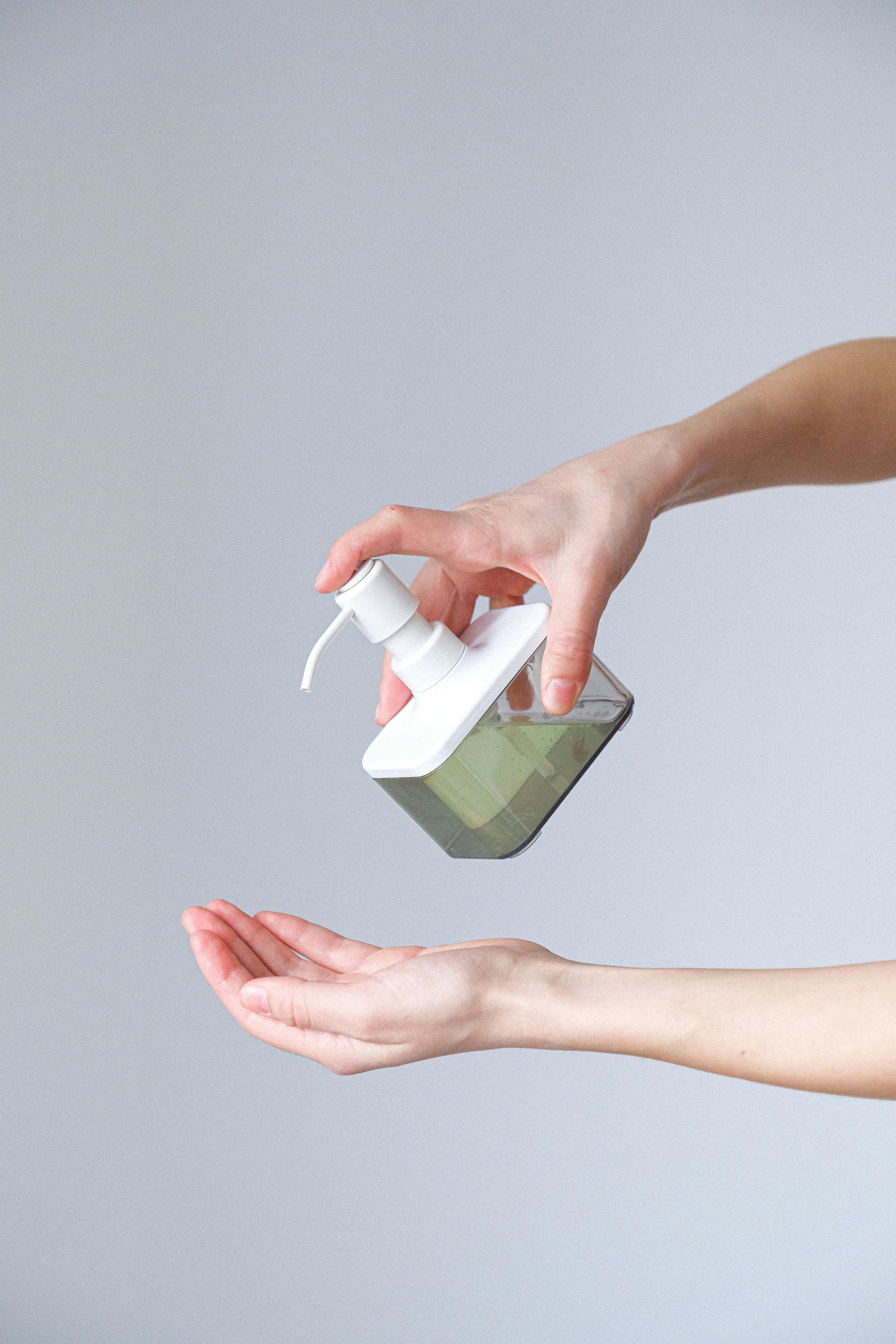 A person applying minoxidil solution to their scalp