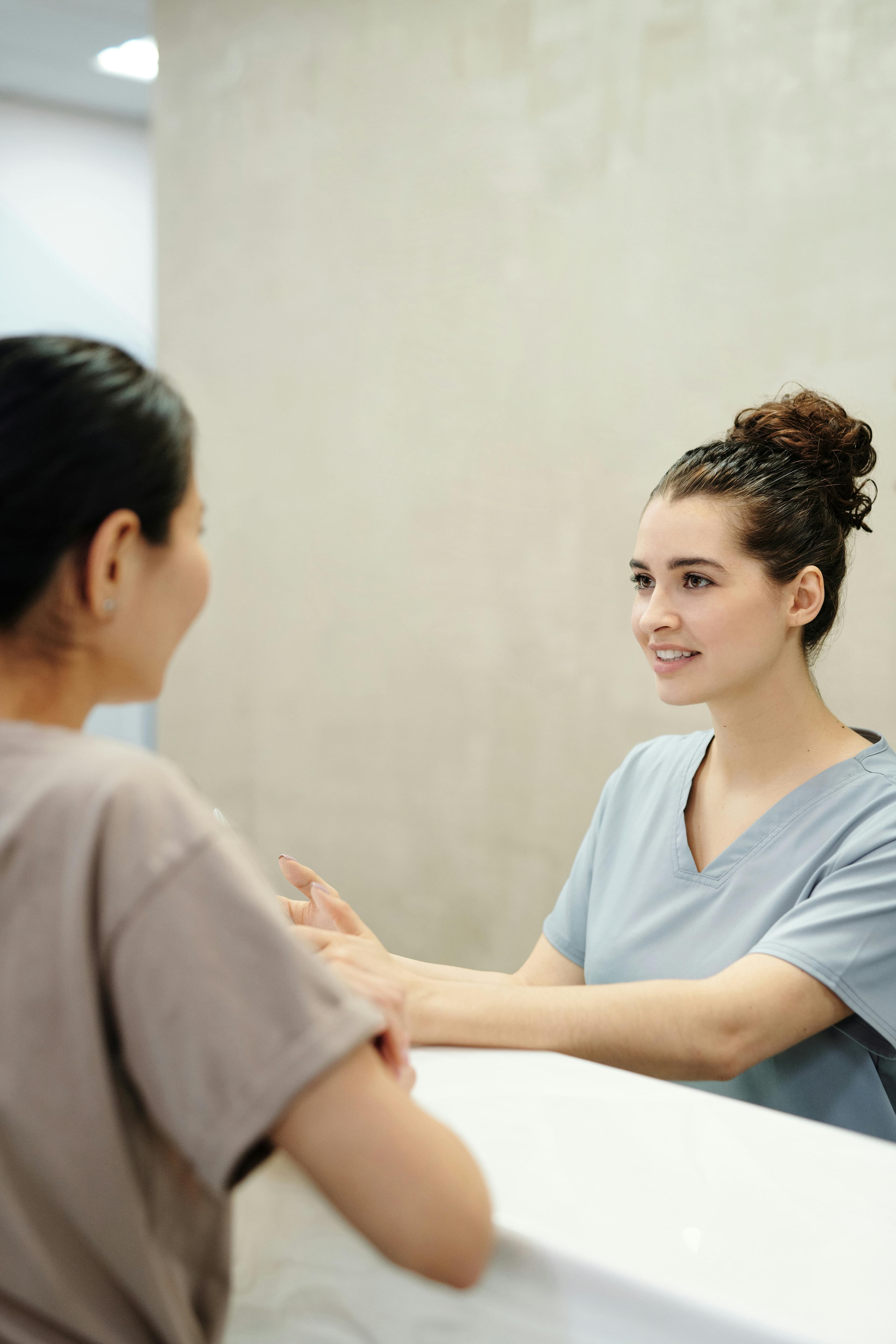 Smiling healthcare professionals interacting with a patient in a welcoming clinic environment