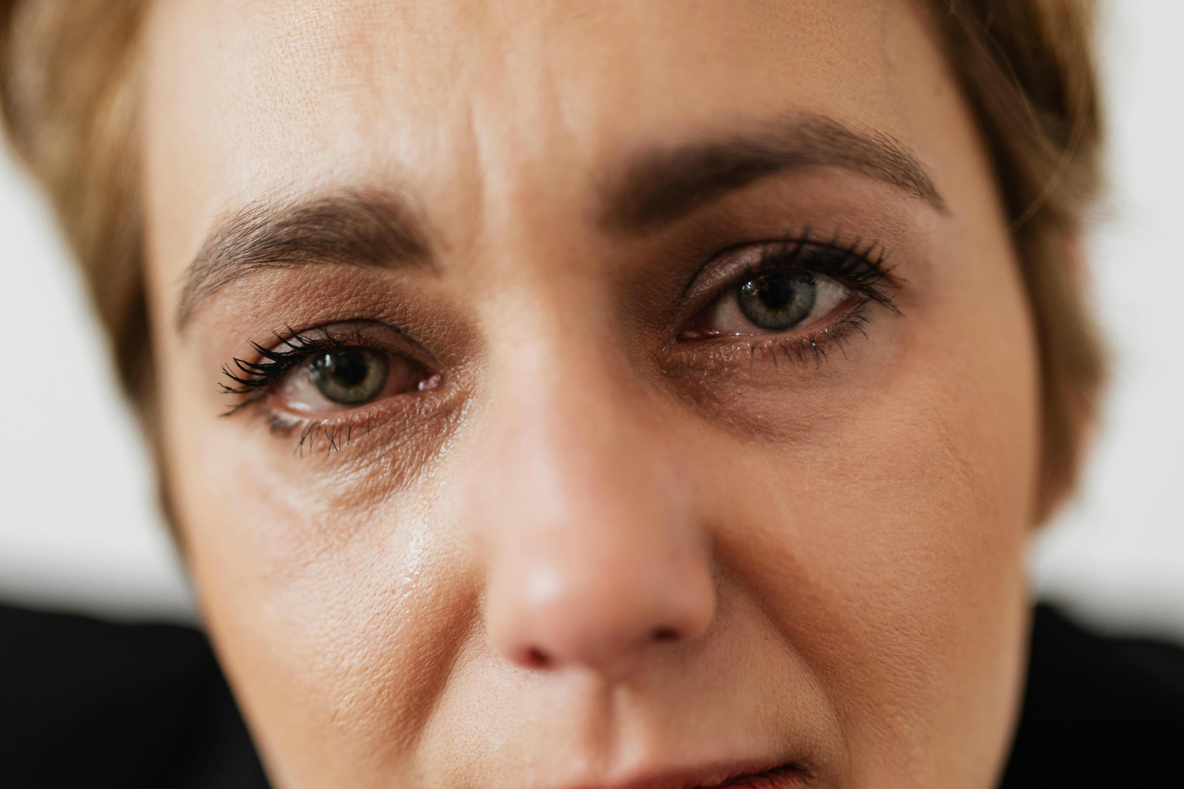A person looking stressed while rubbing their eyes