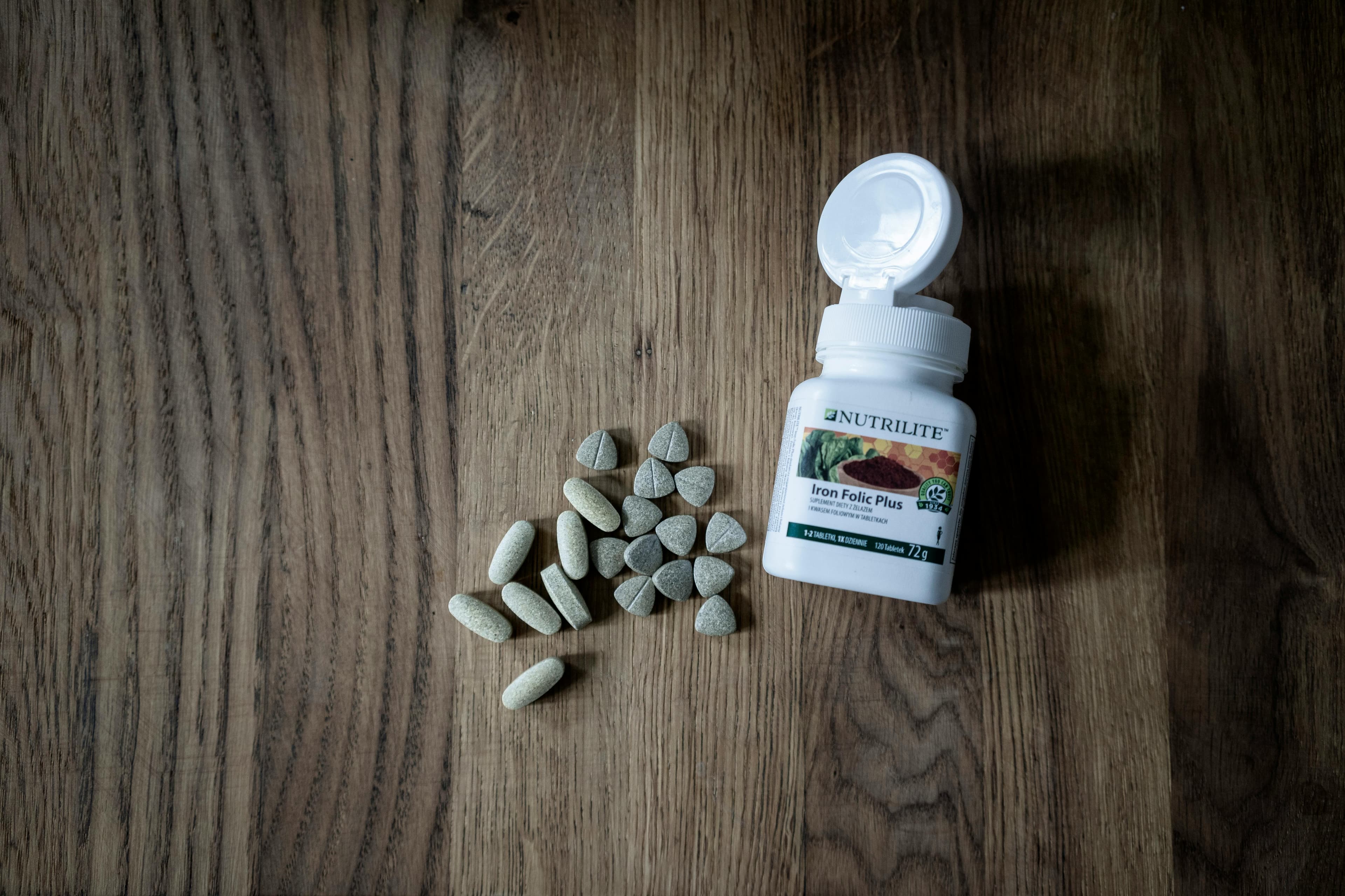 A bottle of Inofolic Alpha supplements next to myo-inositol and folic acid molecular structures