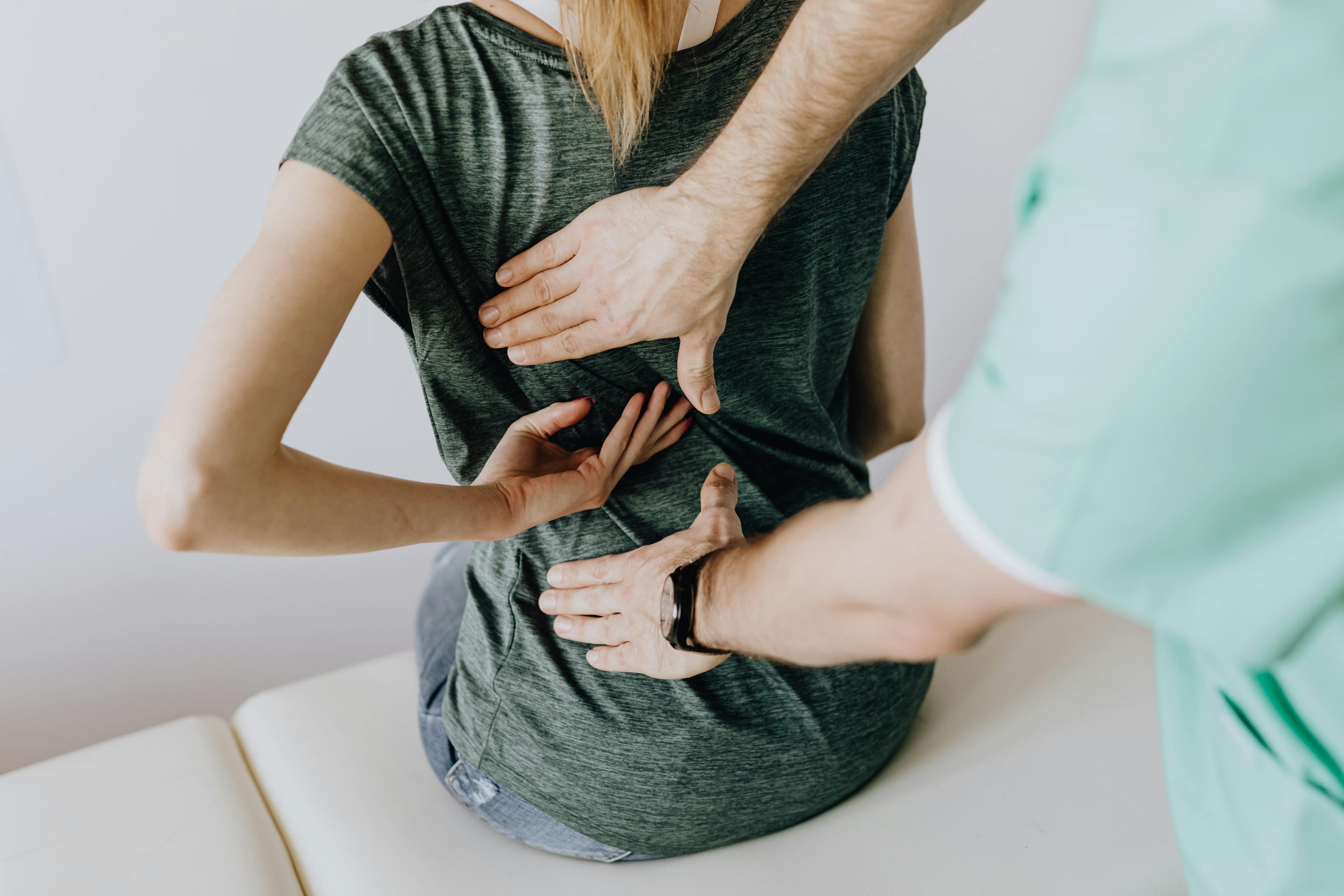 An osteopath performing manual therapy on a patient's back
