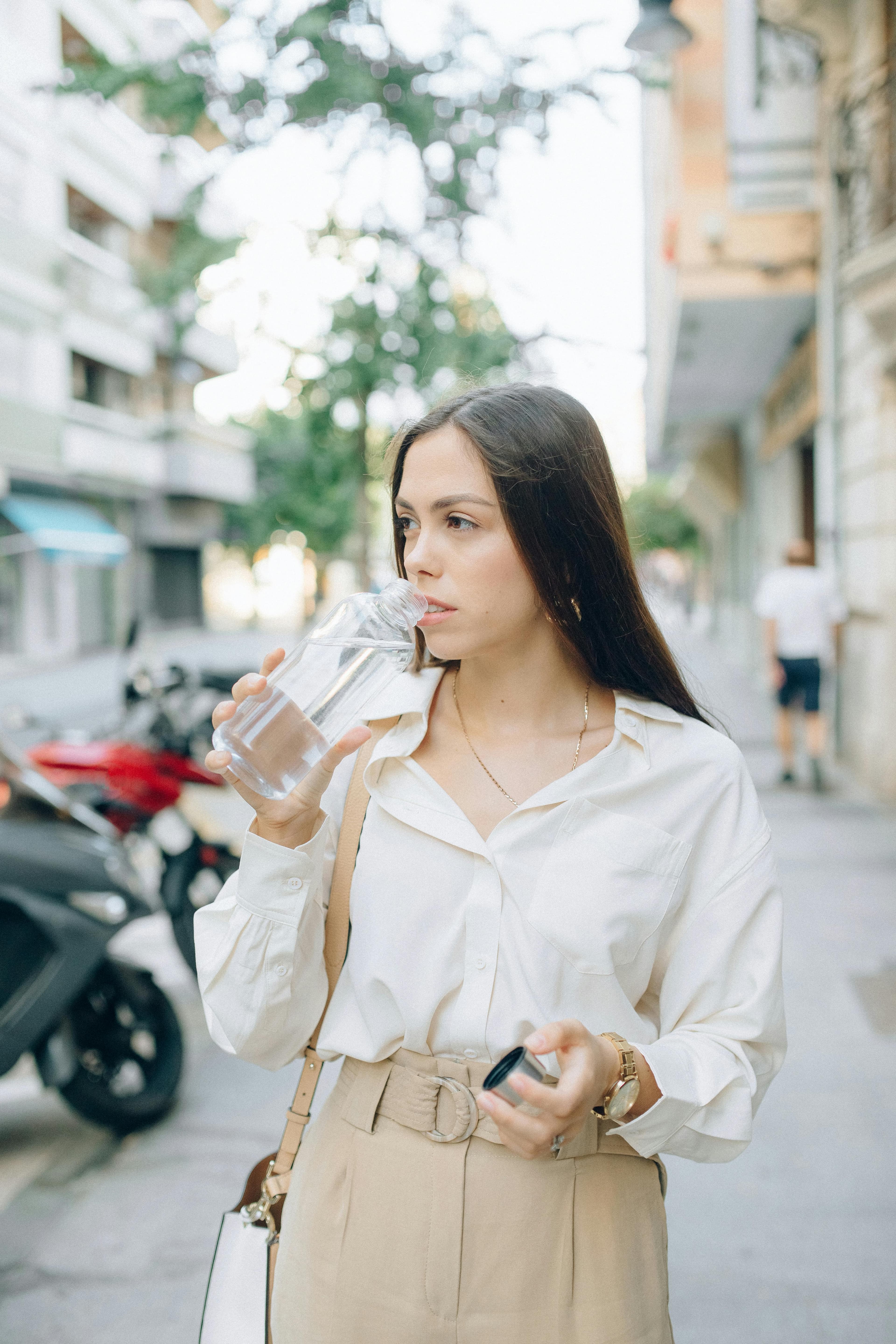Person drinking water after exercise, emphasizing the importance of hydration in preventing muscle cramps