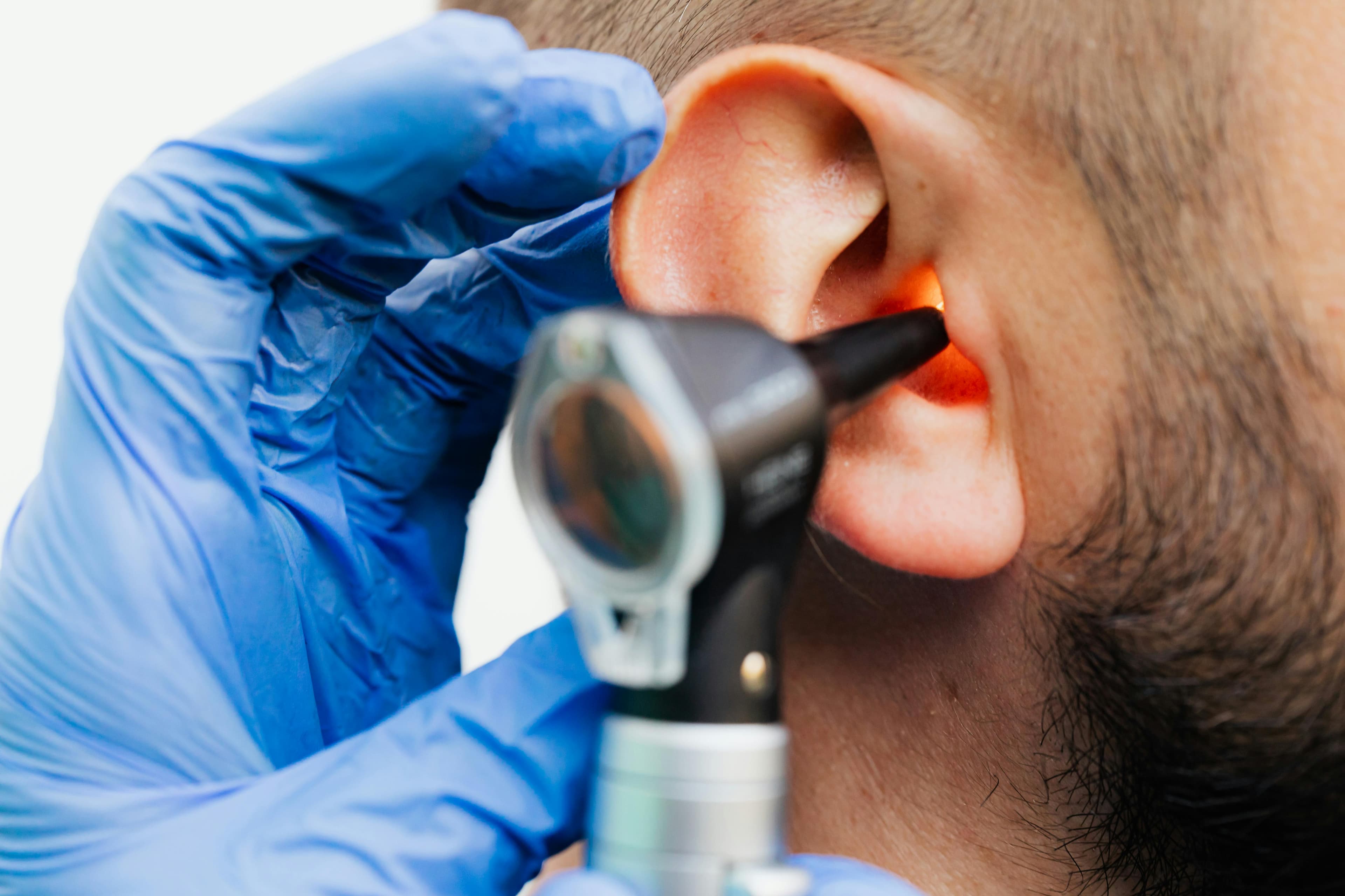 Doctor examining a patient's ear with an otoscope