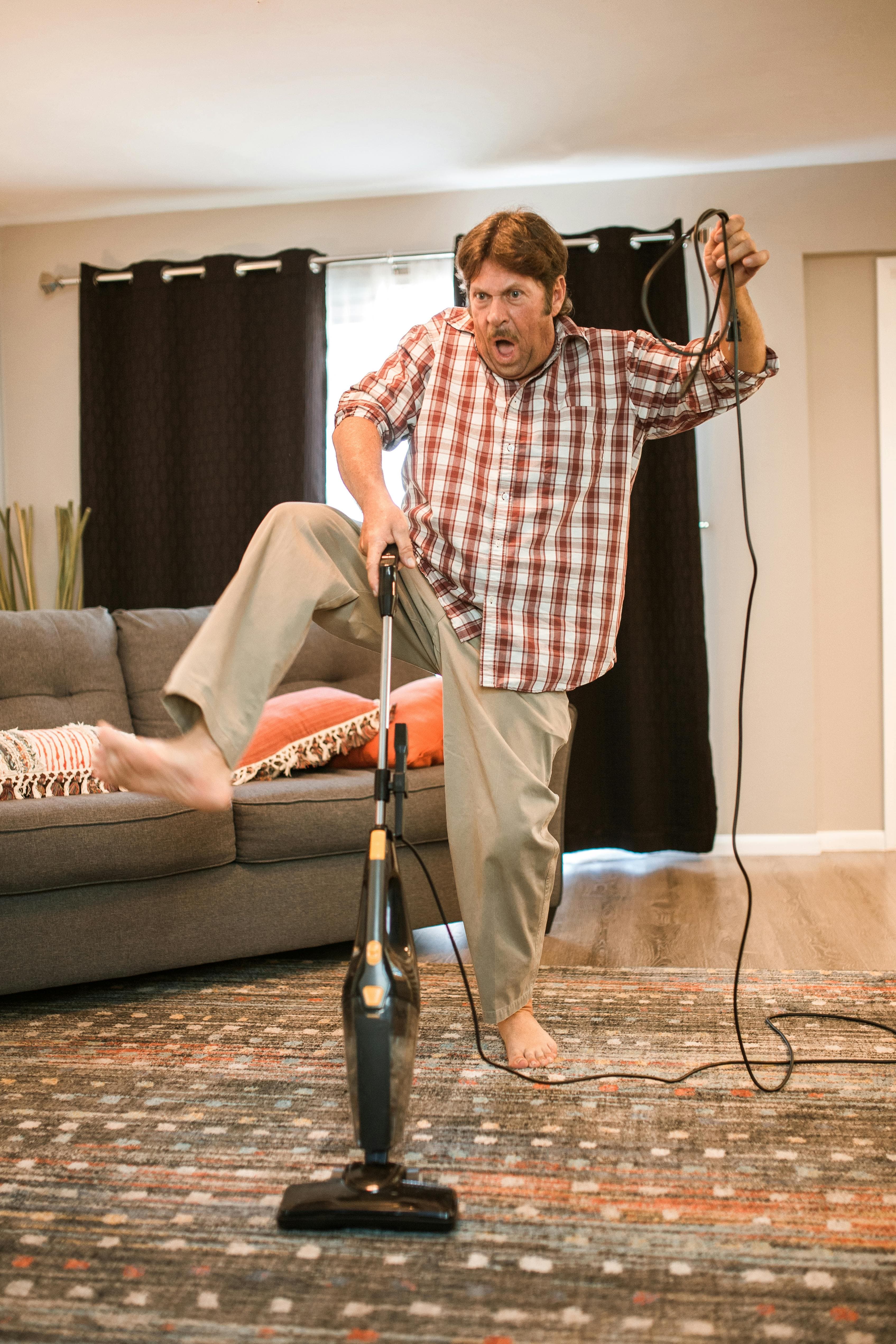 Person vacuuming a carpet to remove carpet beetles