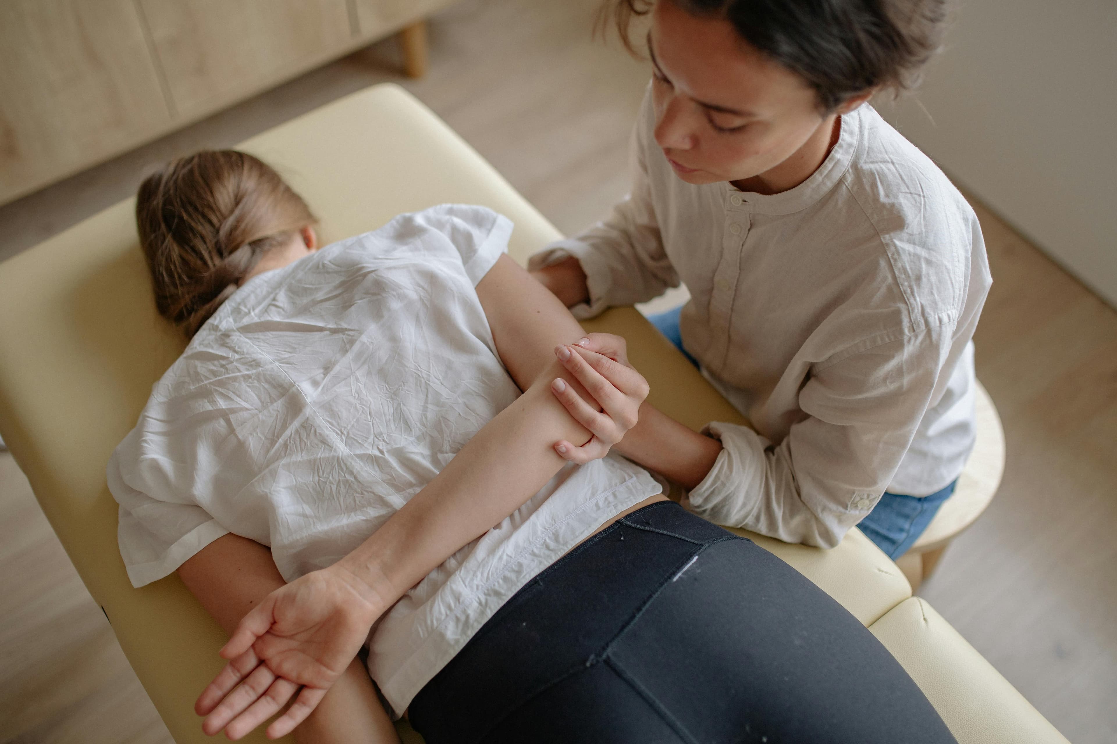 A patient receiving an acupuncture treatment on a massage table