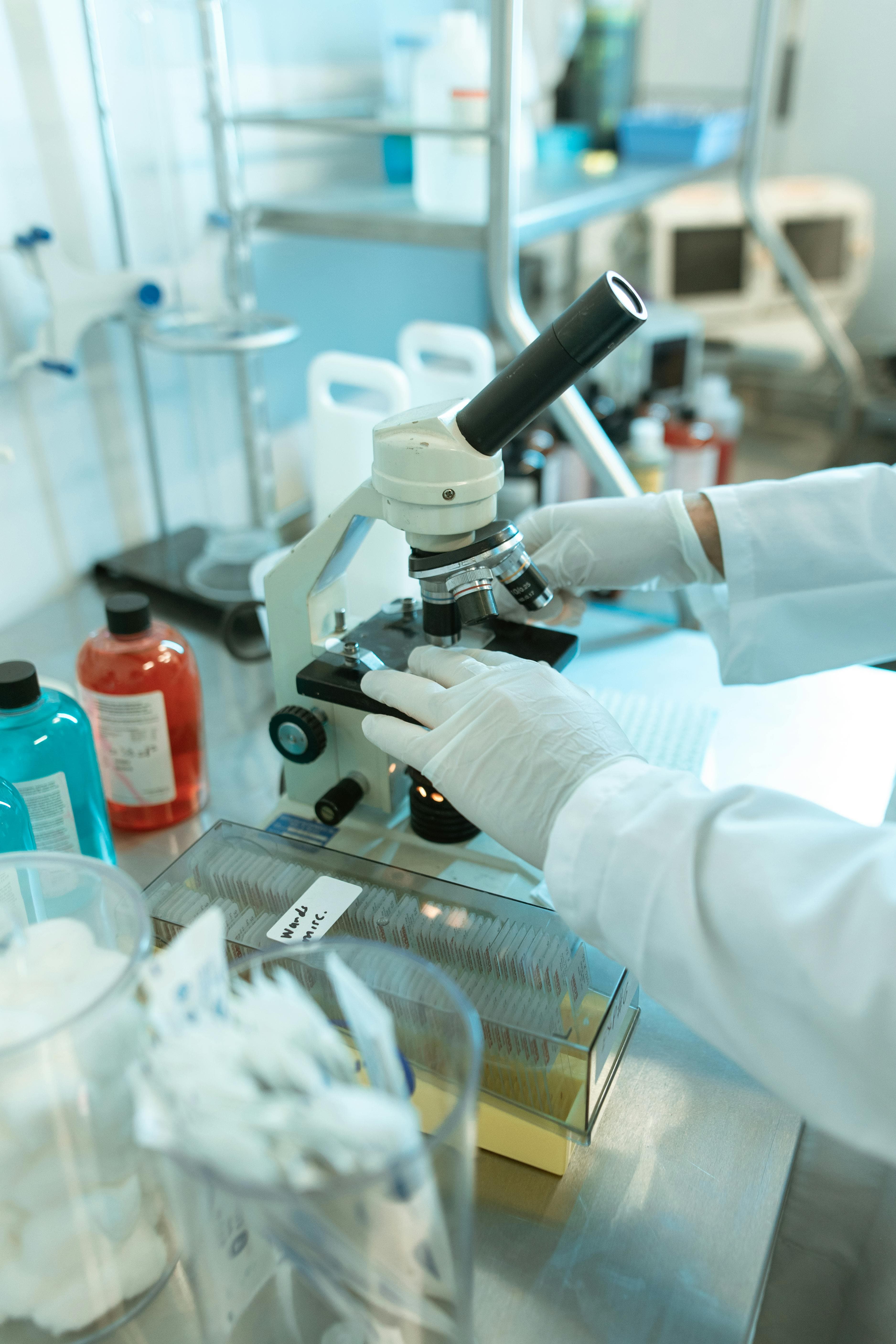 A pathologist examining slides under a microscope