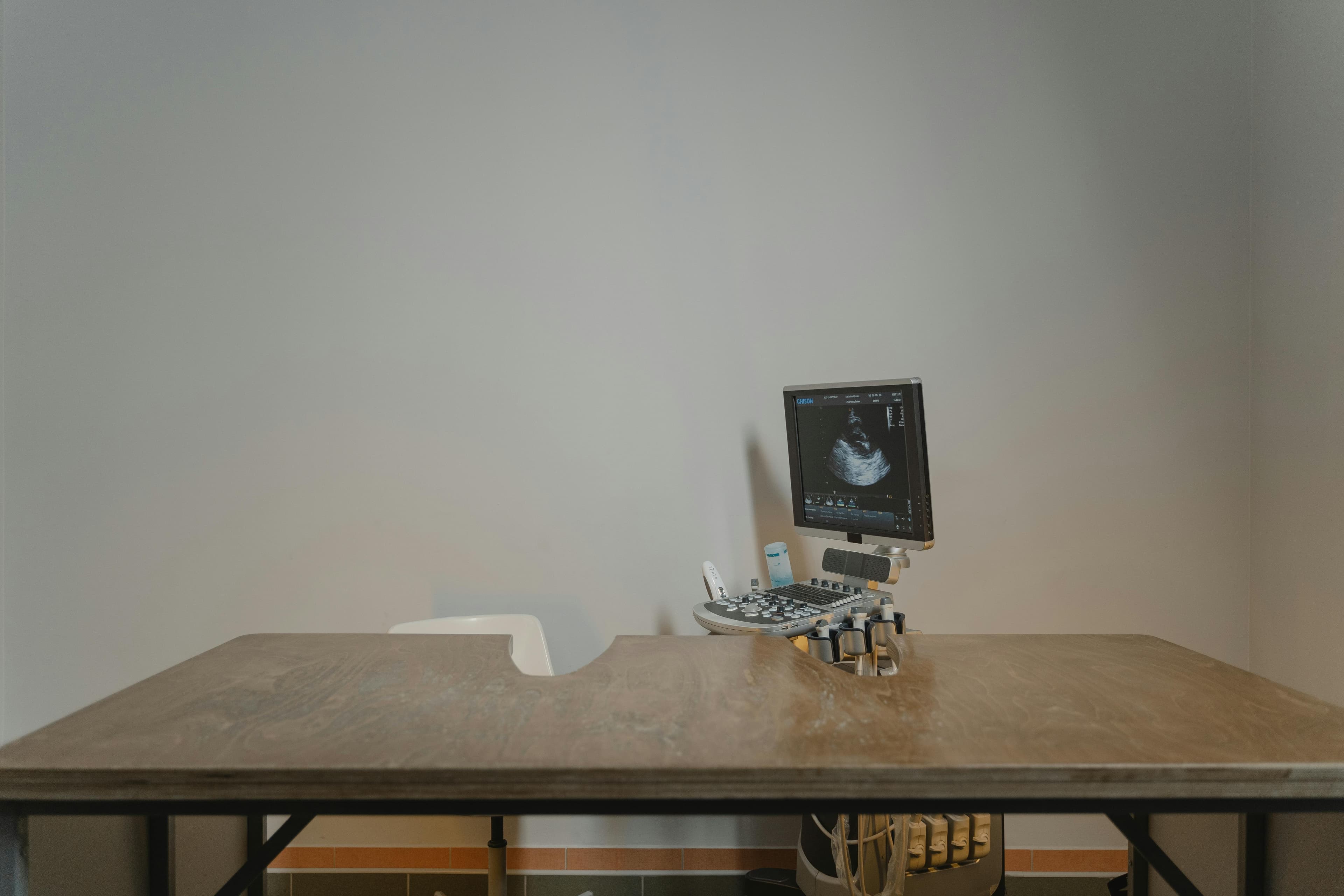 A medical professional performing a thyroid ultrasound on a patient