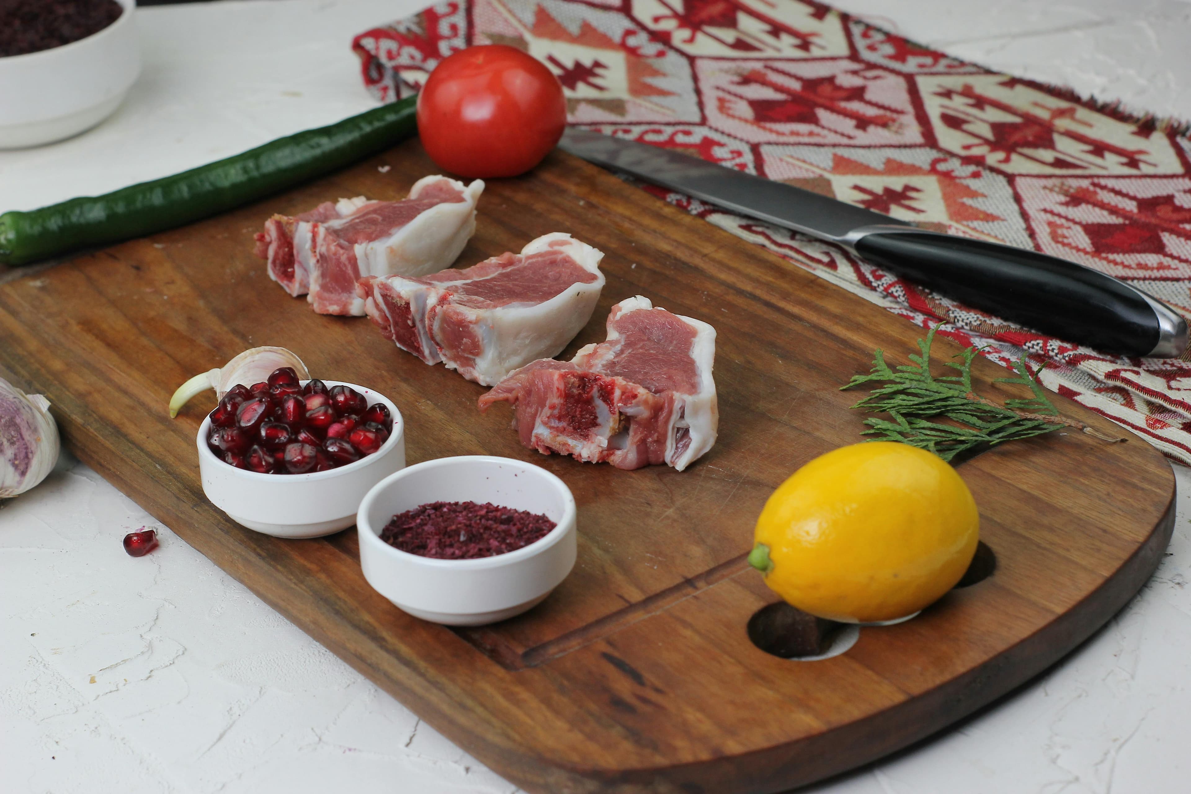 Fresh red snapper fillet on a cutting board with lemon slices and herbs