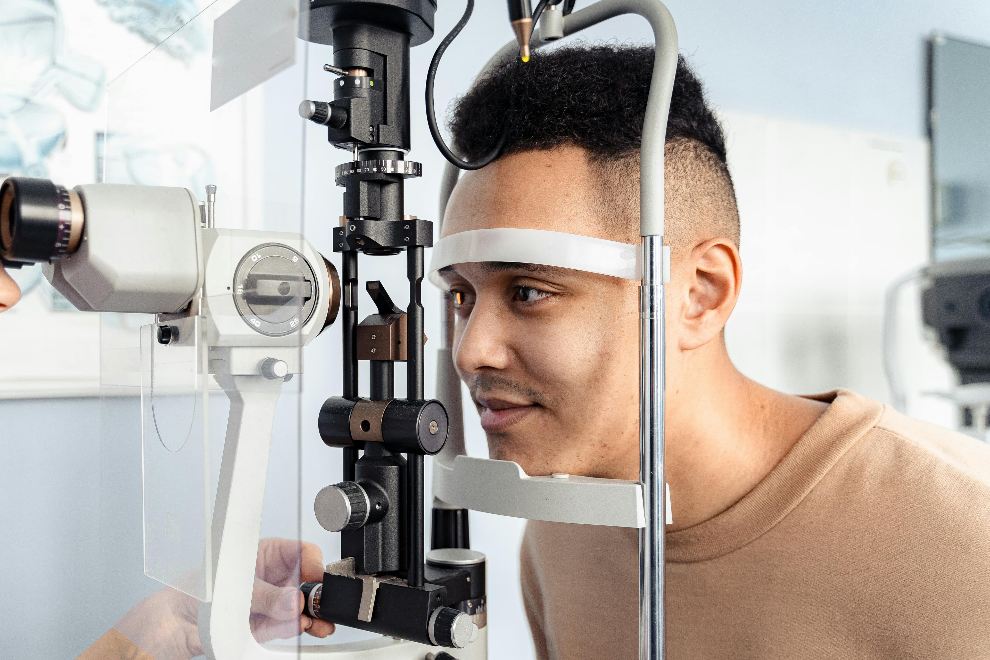 An optometrist examining a patient's eye with a slit lamp