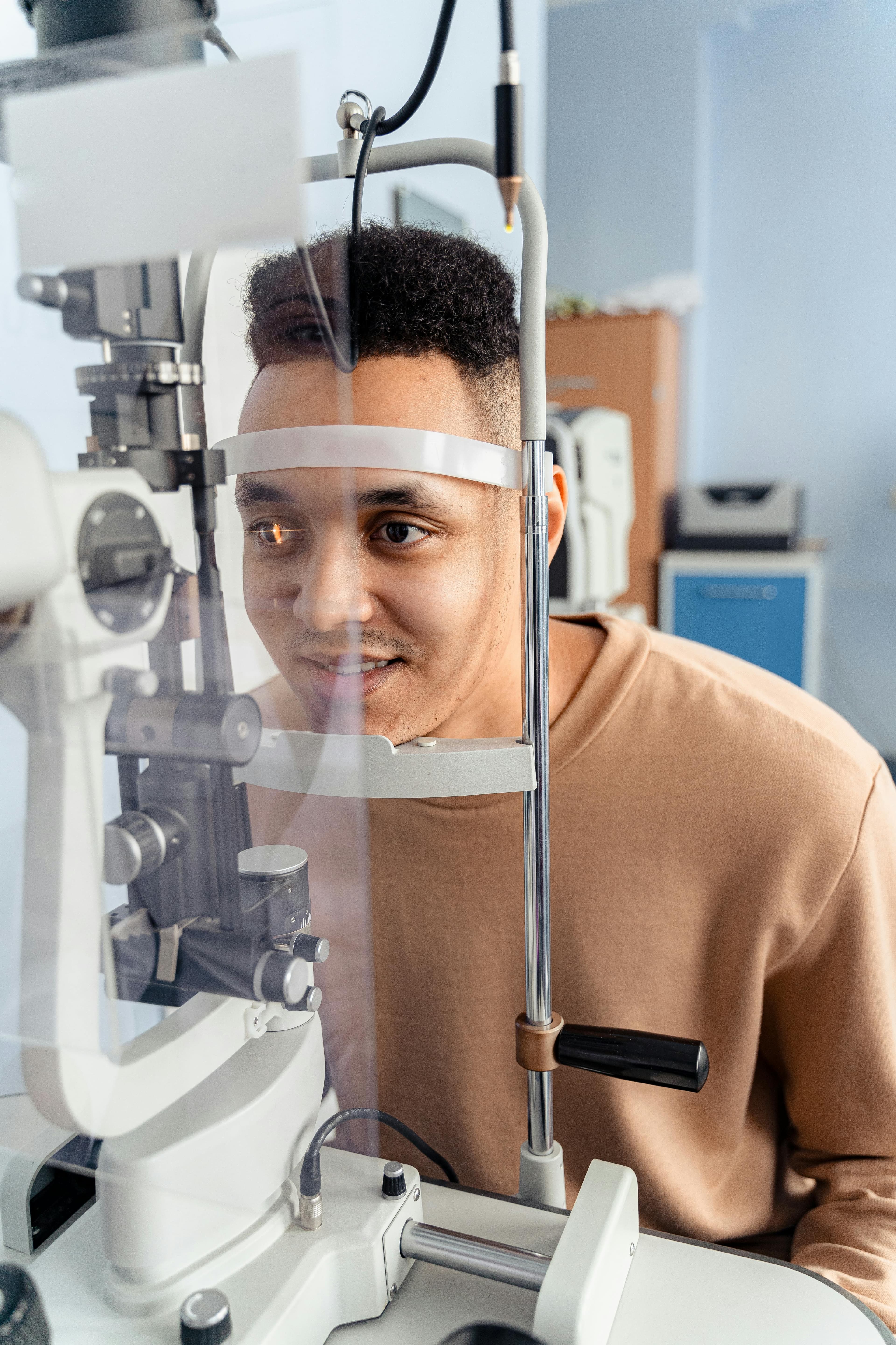 An optometrist examining a patient's eyes with specialized equipment