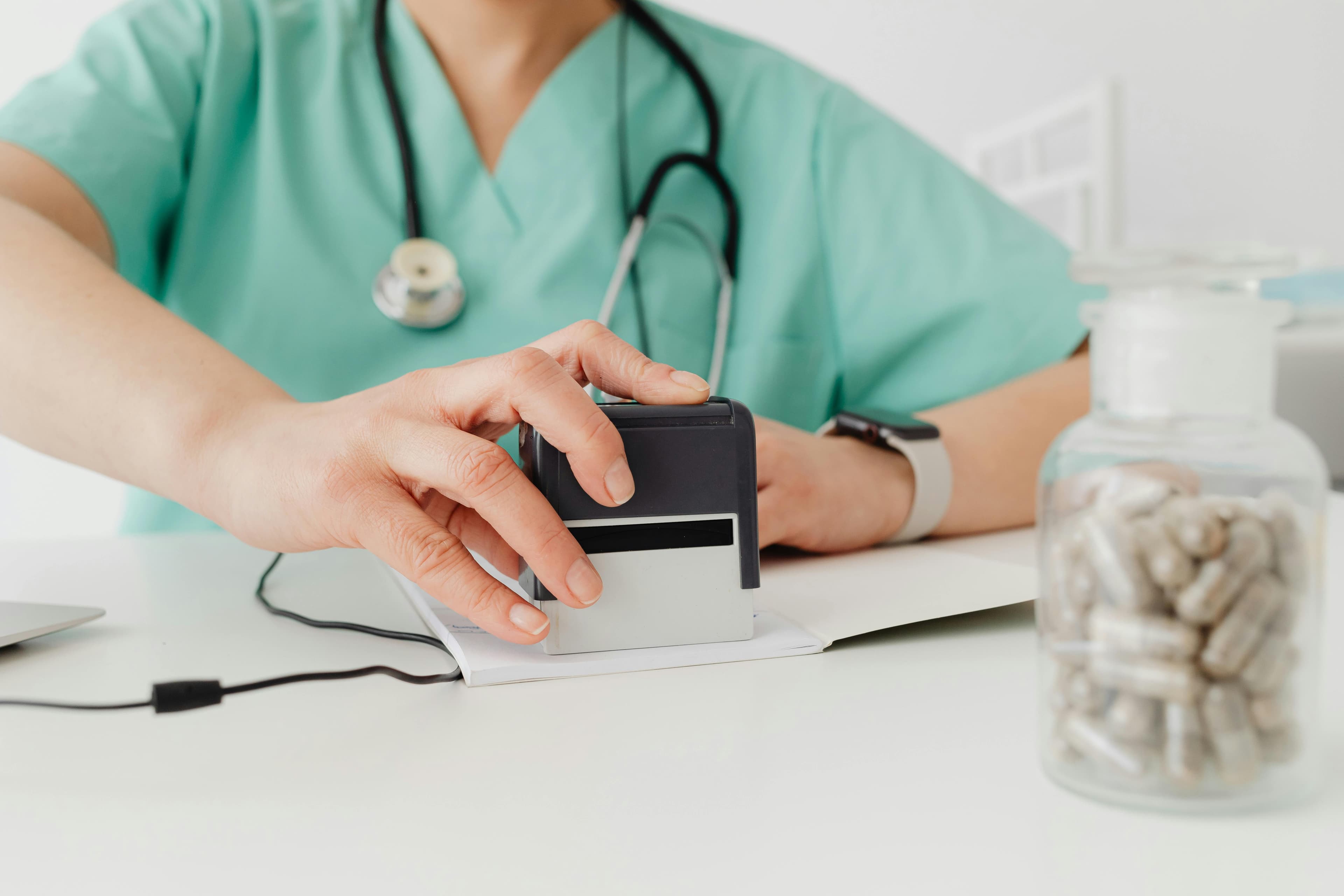 A bottle of doxycycline capsules next to a prescription pad