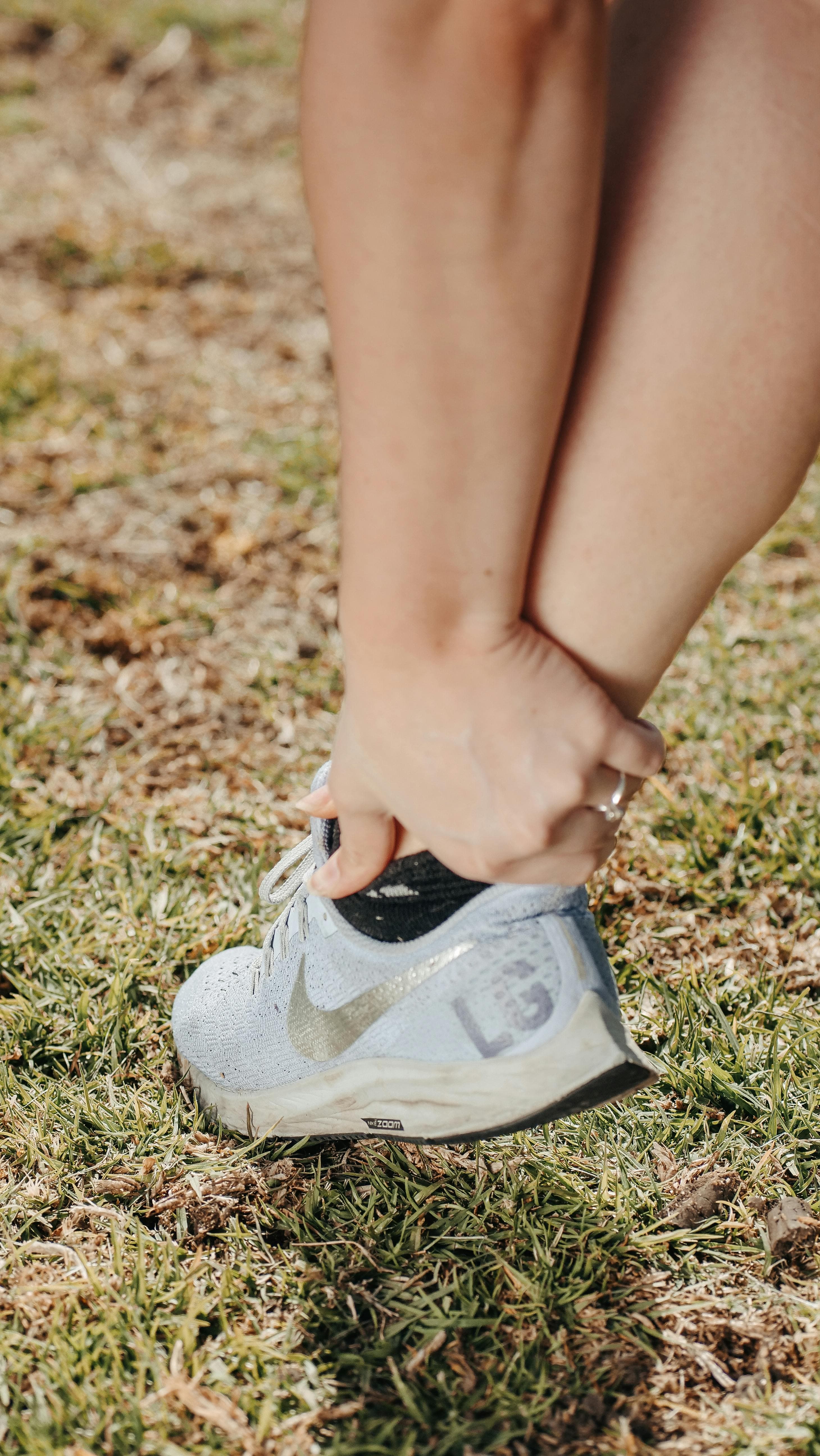Person holding their foot in pain due to plantar fasciitis