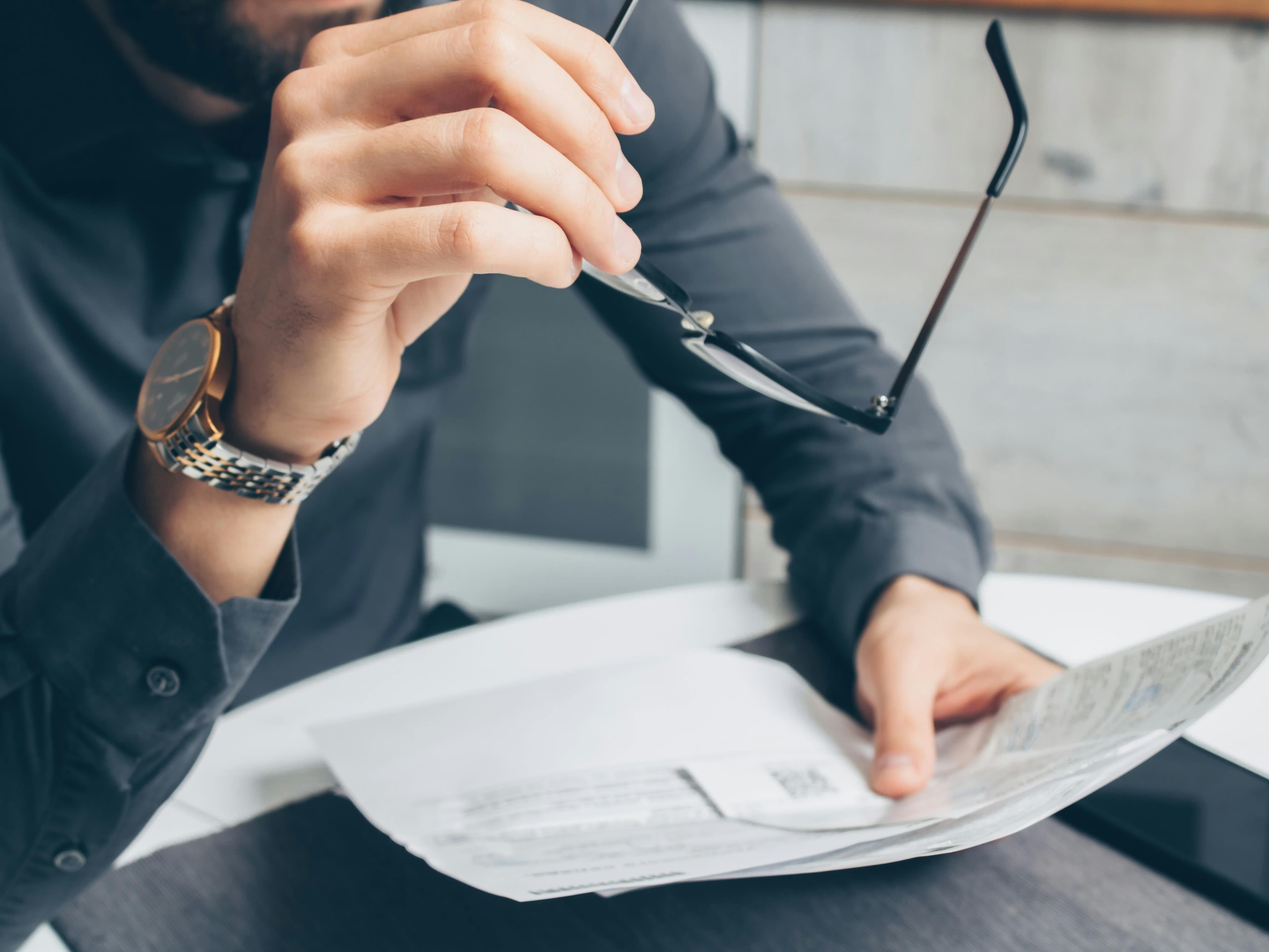 A medical student looking worried while reviewing financial documents and loan statements