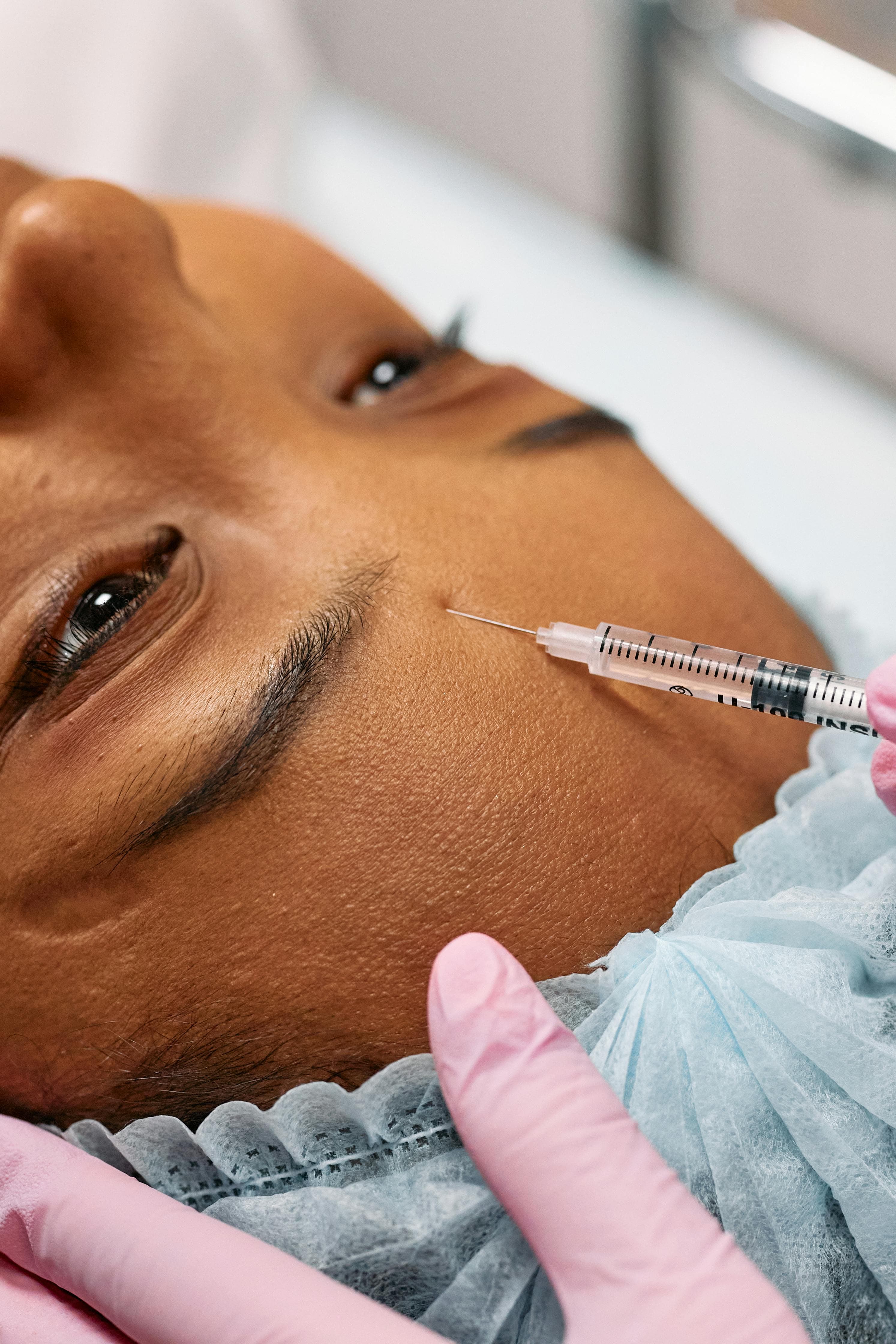 A person receiving a non-invasive facial treatment in a medical spa setting