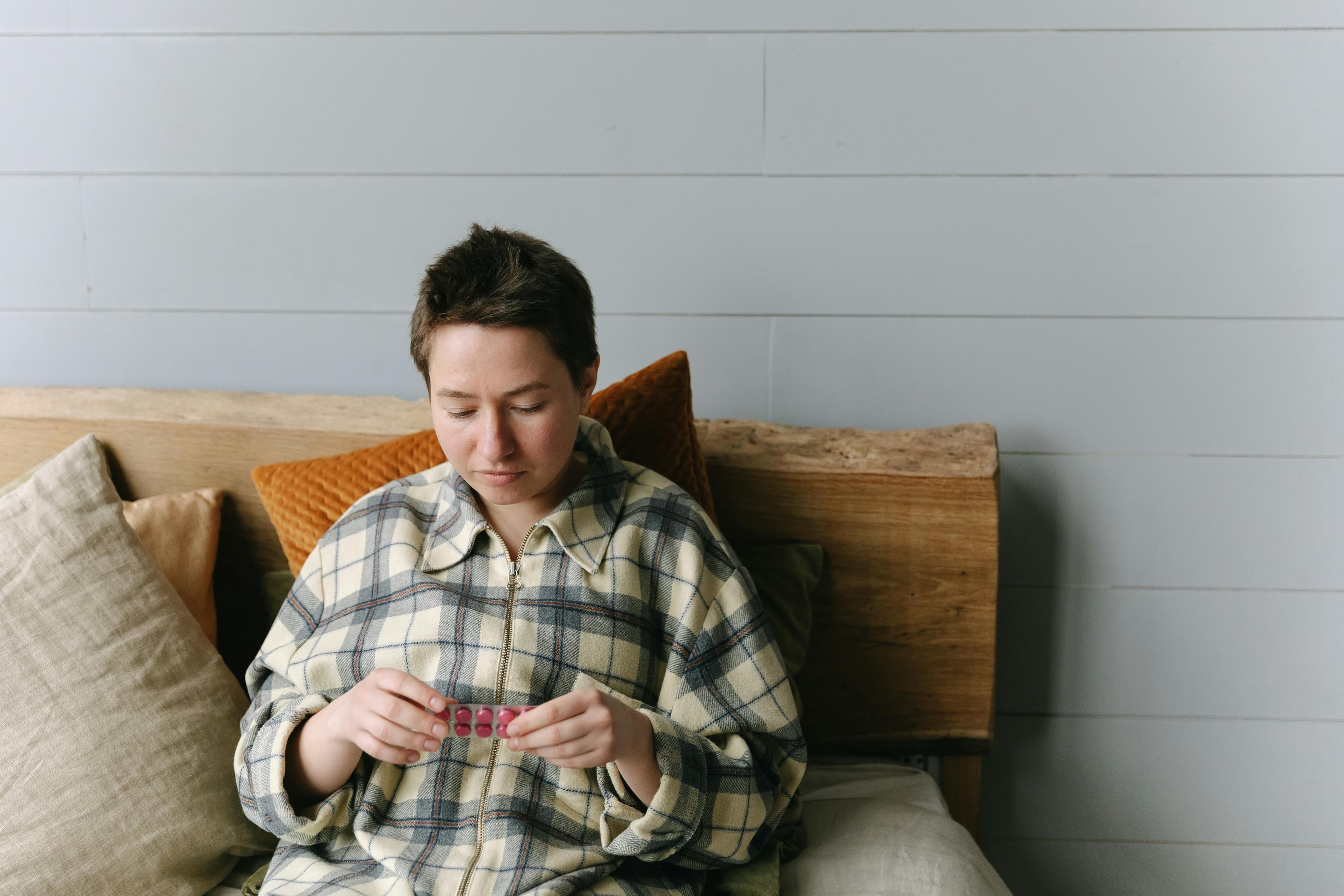 A person resting at home after lipoma removal surgery with medication and ice pack nearby