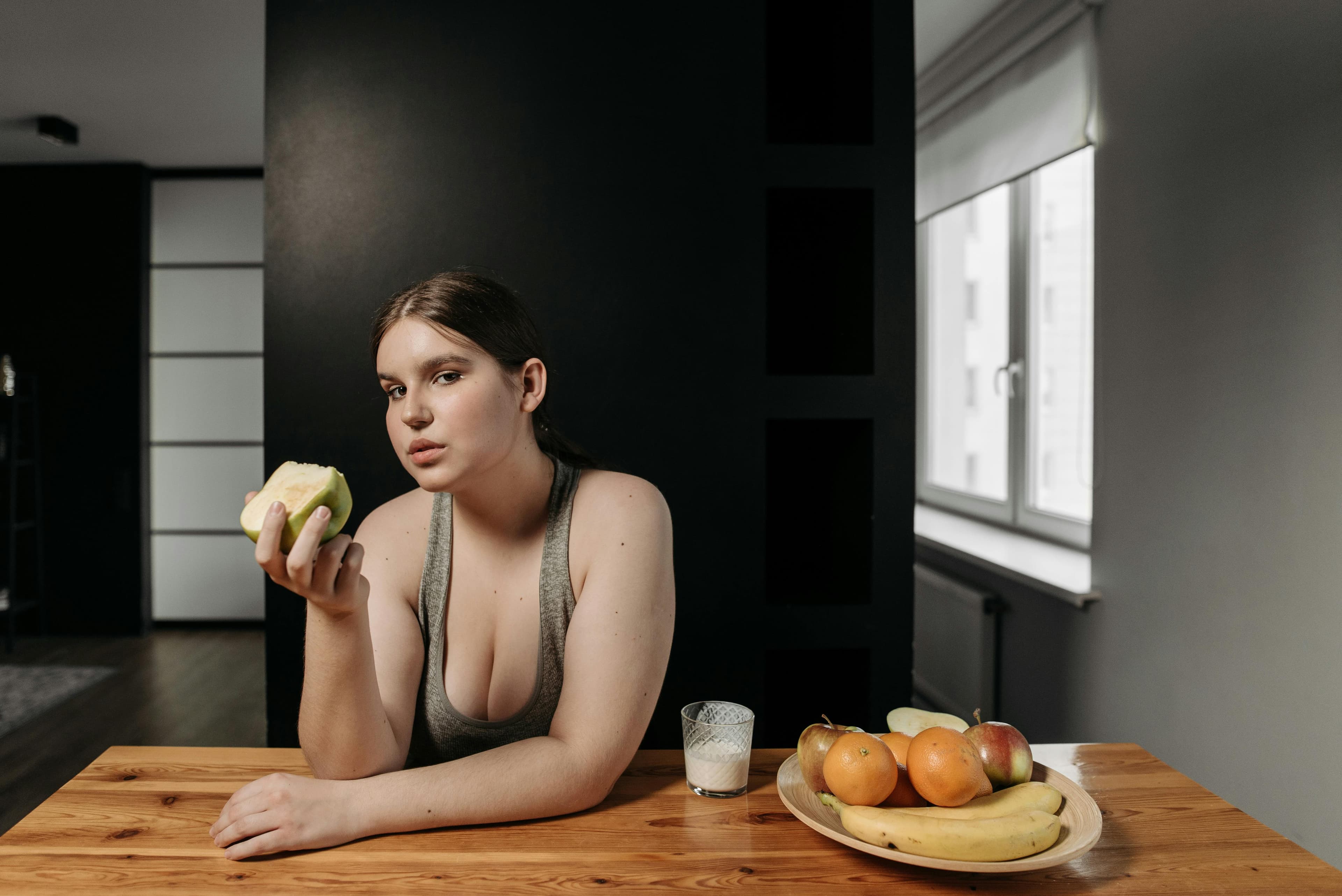 Person eating a balanced meal with fruits and vegetables, symbolizing a healthy lifestyle for eye health