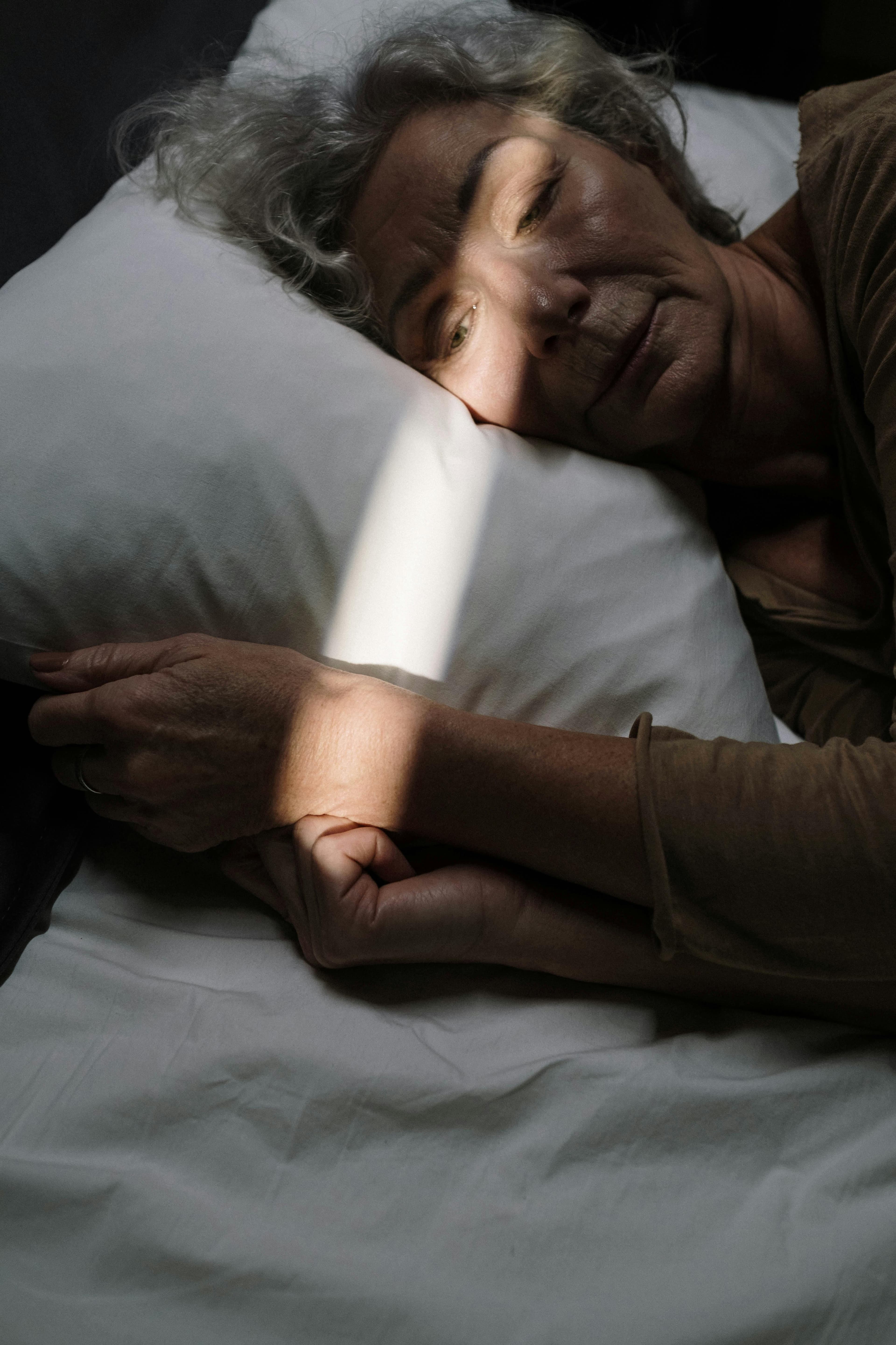 An elderly woman peacefully sleeping in bed