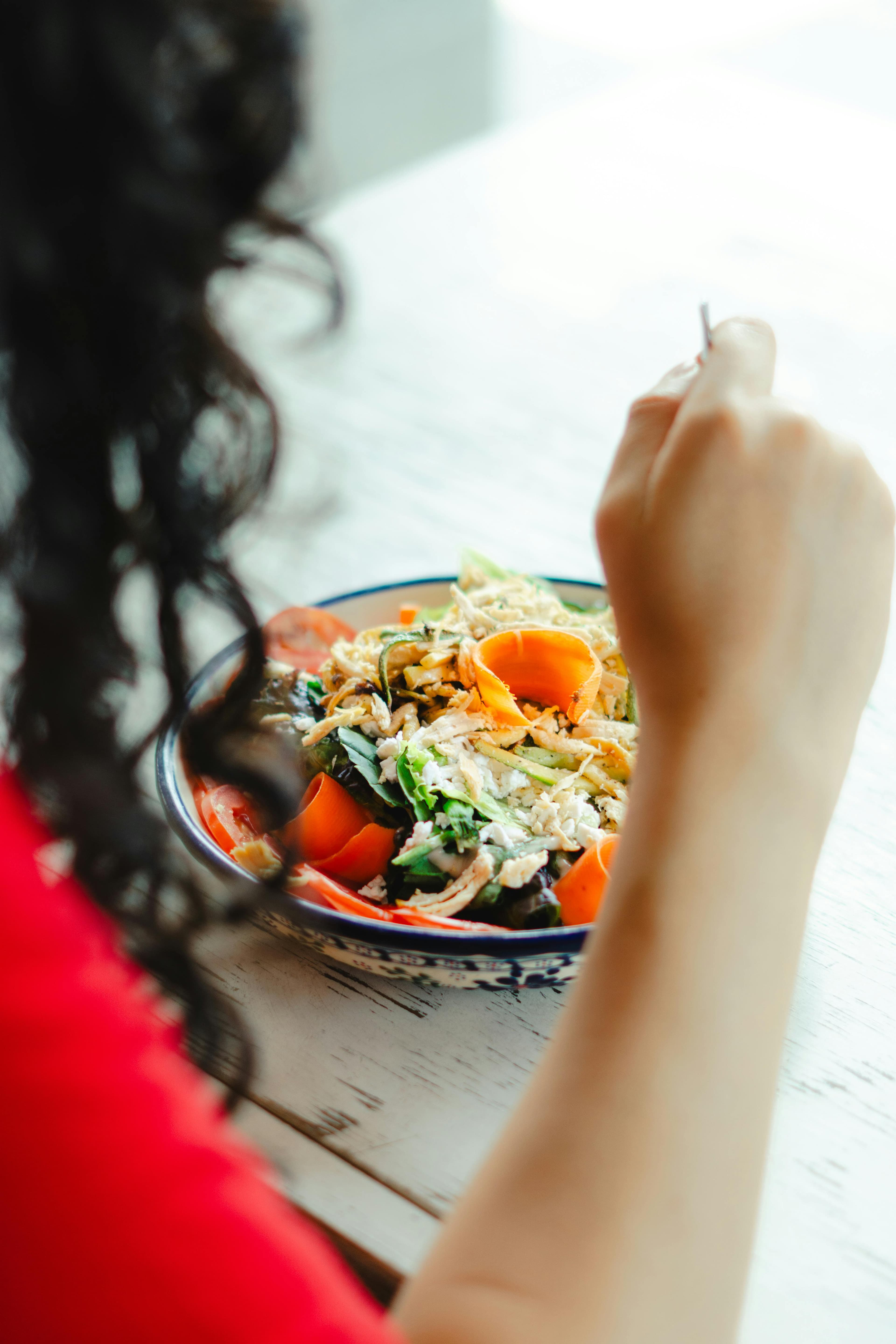 A pregnant woman eating a balanced meal with fruits, vegetables, and lean protein