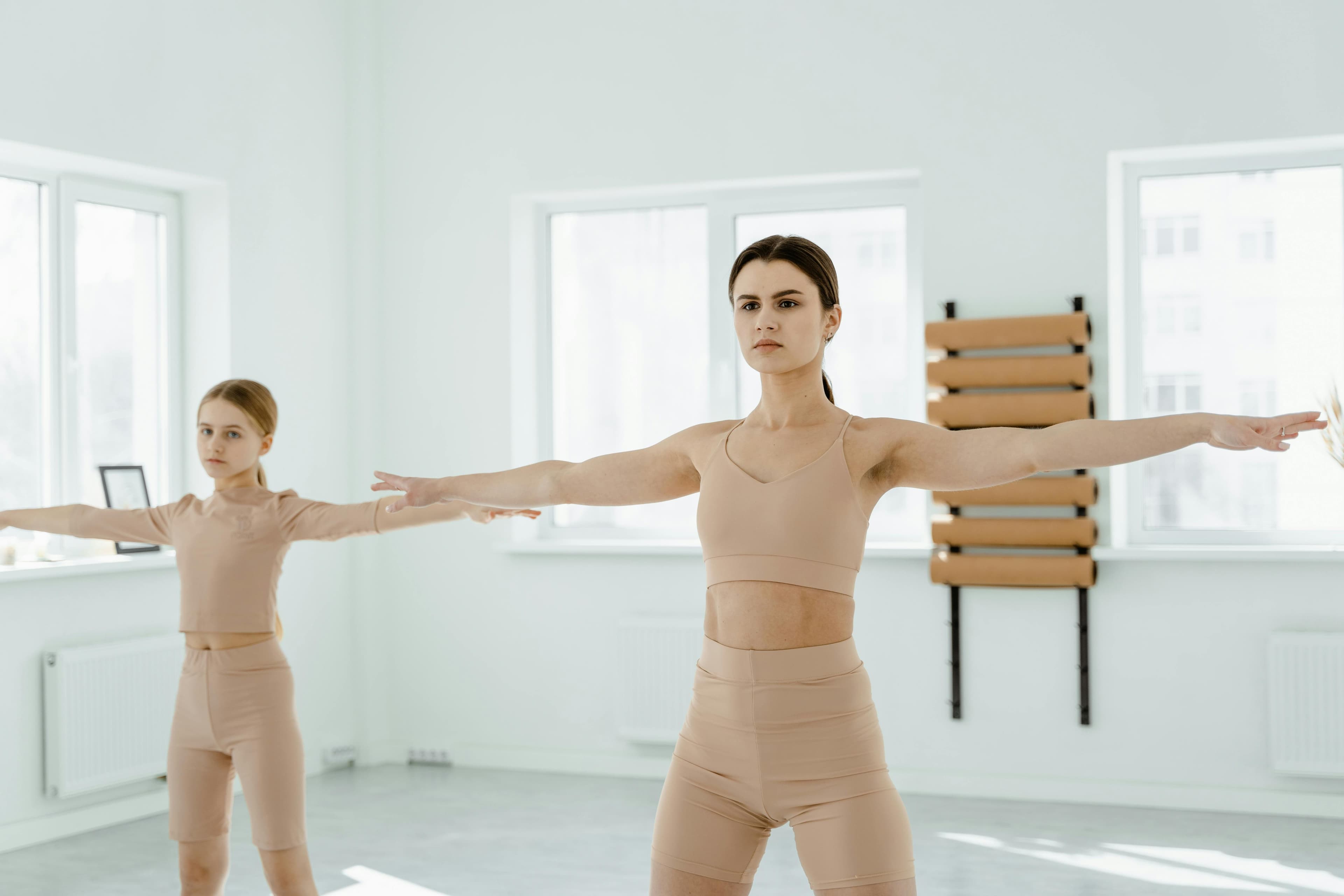 Energetic group fitness class with instructor leading participants in a bright studio
